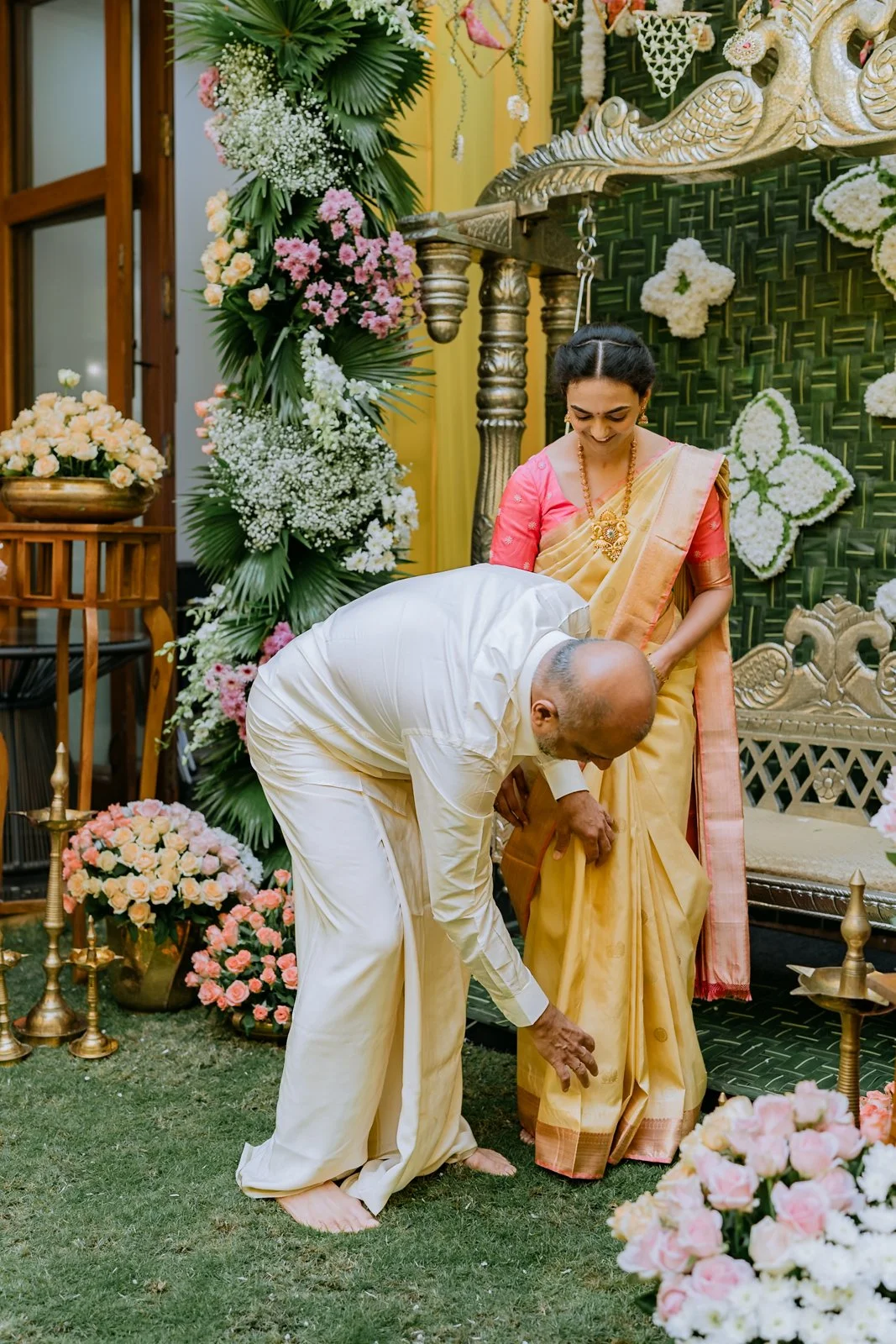 Father adjusting Shrishti's saree pleats in the garden
