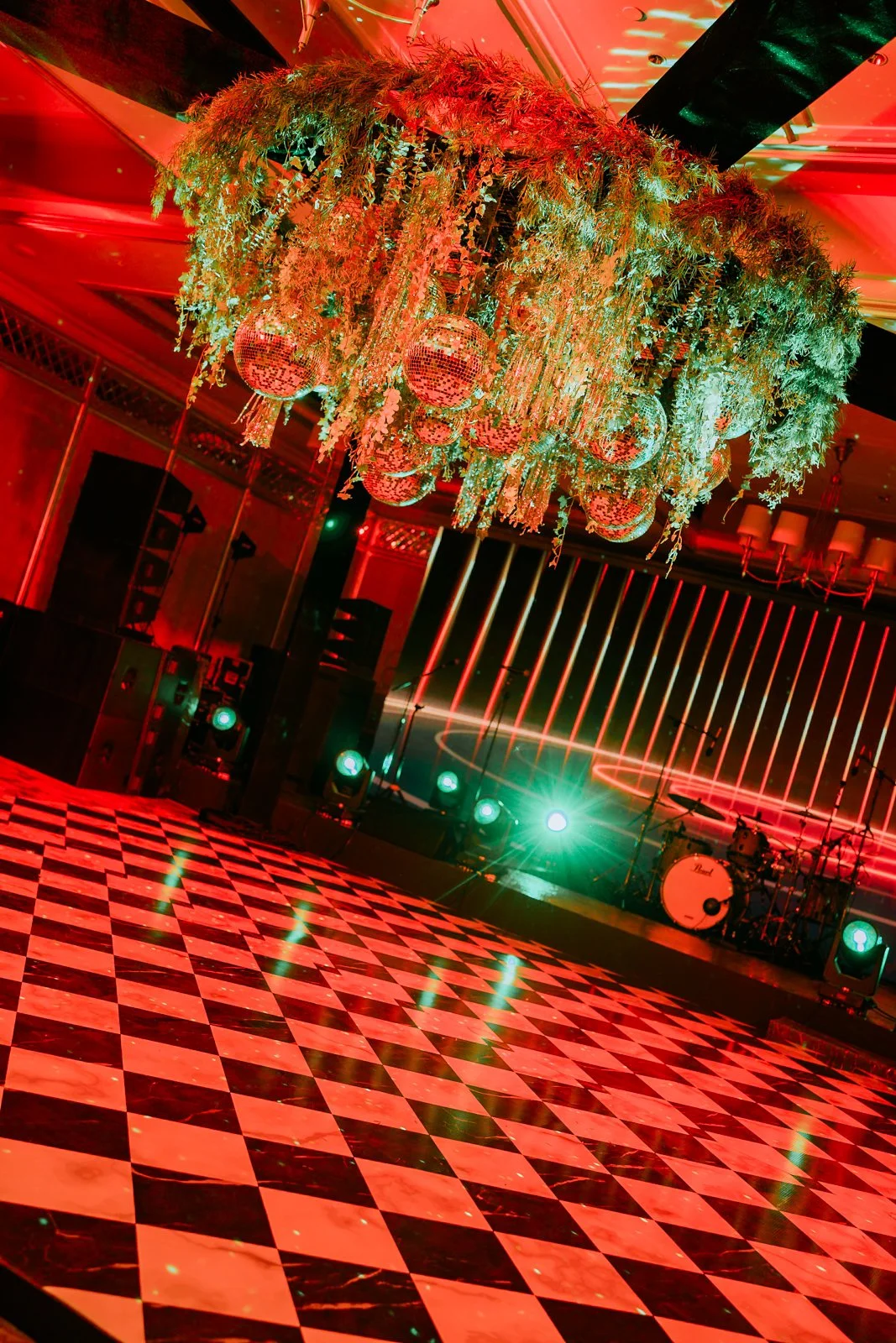 Checkerboard dance floor under red lights at the cocktail