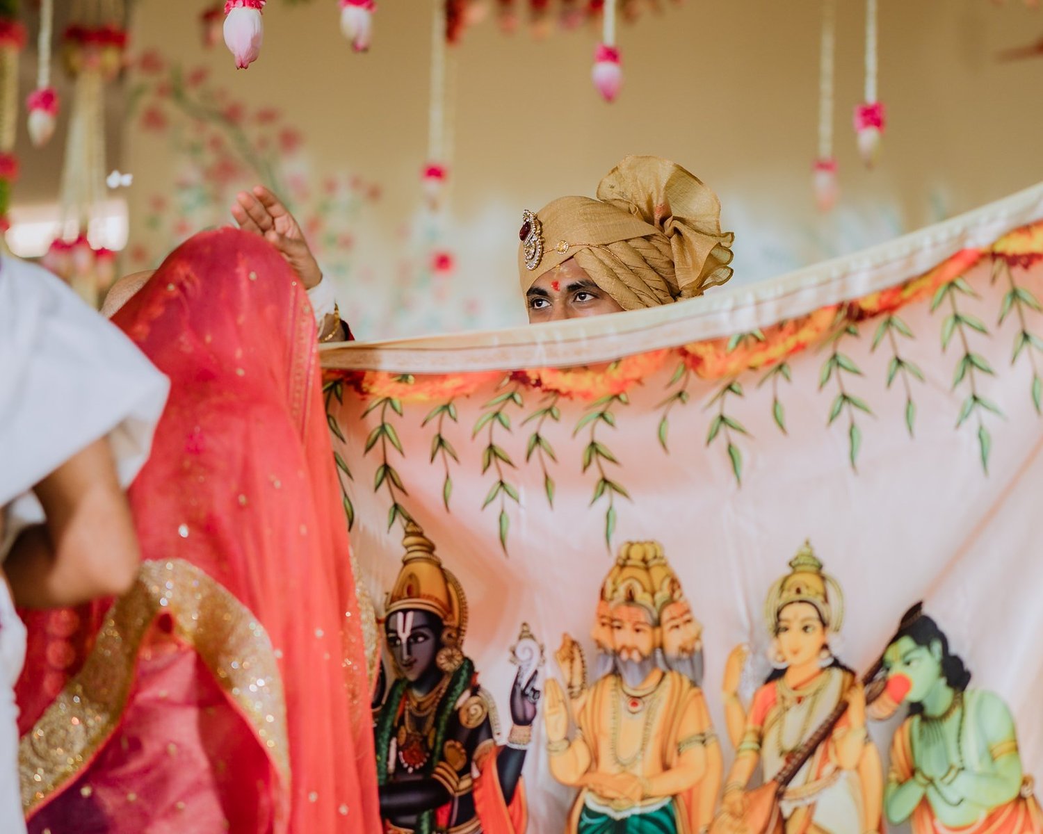 Akhil peeking over the antarpat curtain at his bride