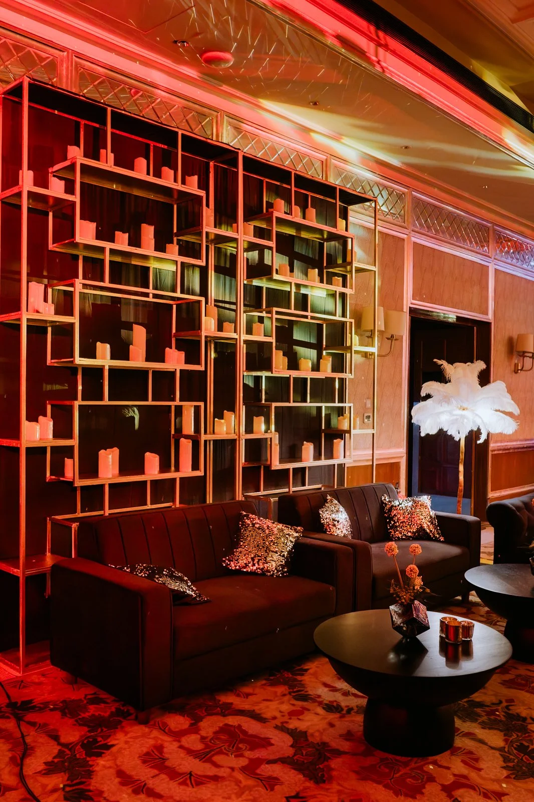 Lounge corner with red shelving and velvet sofas