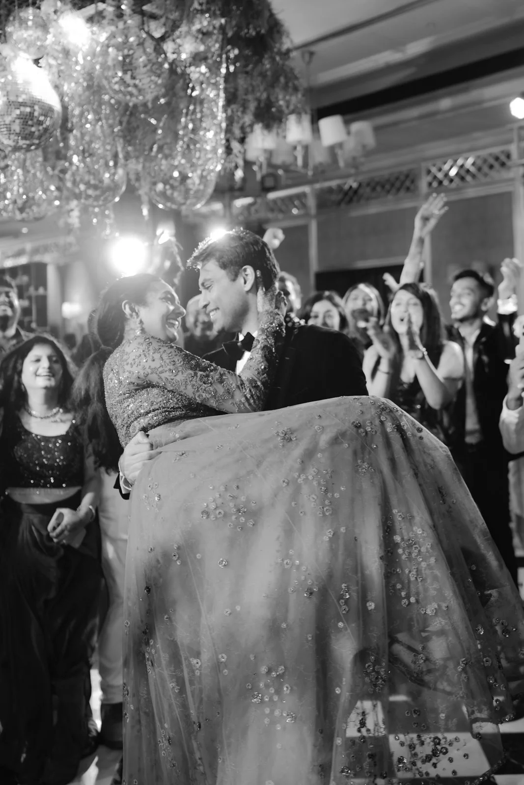 Akhil carrying Shrishti through the crowd, black and white