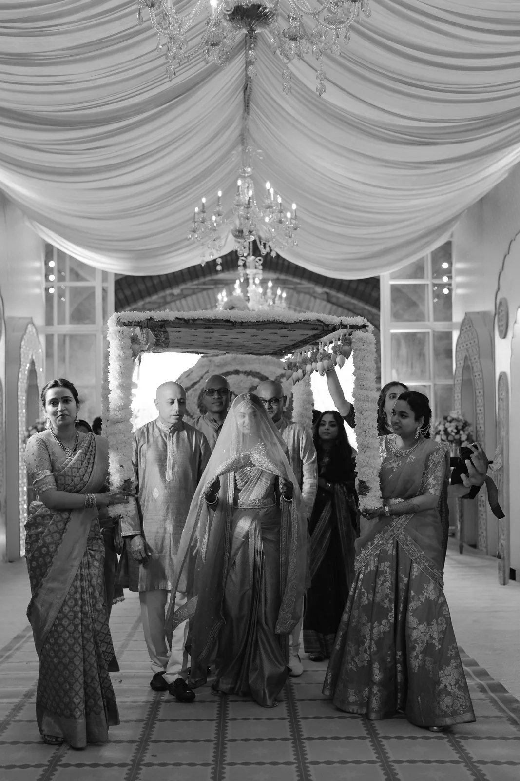 Shrishti walking in beneath the flower canopy, black and white