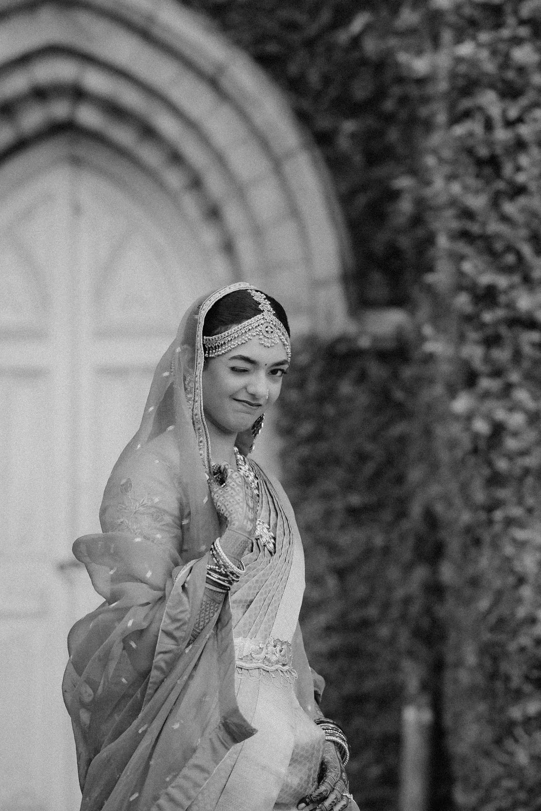 Shrishti at a palace doorway in her veil, black and white