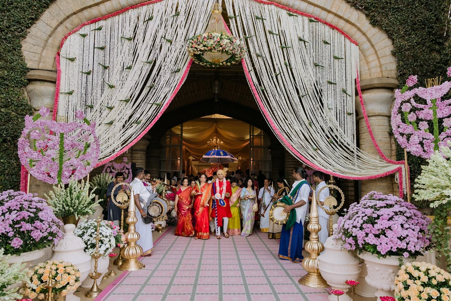 Groom's party entering through a jasmine curtain gateway at Bangalore Palace