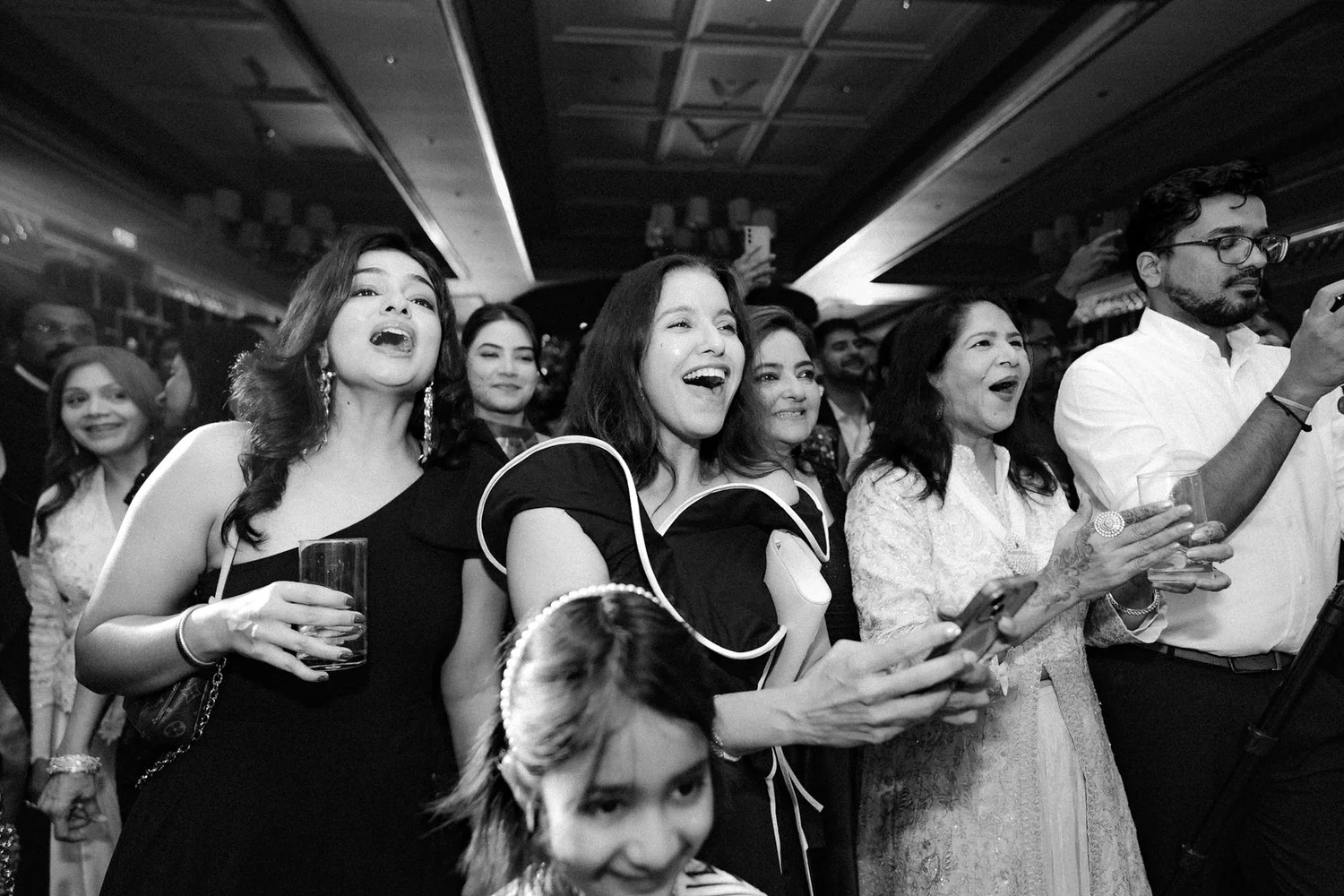 Friends cheering from the crowd, black and white