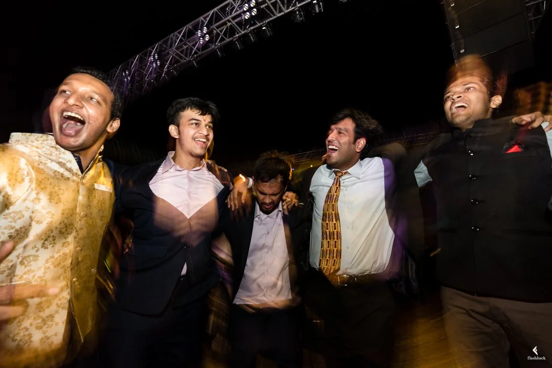 Group of men celebrating and laughing at a night event on an outdoor stage.