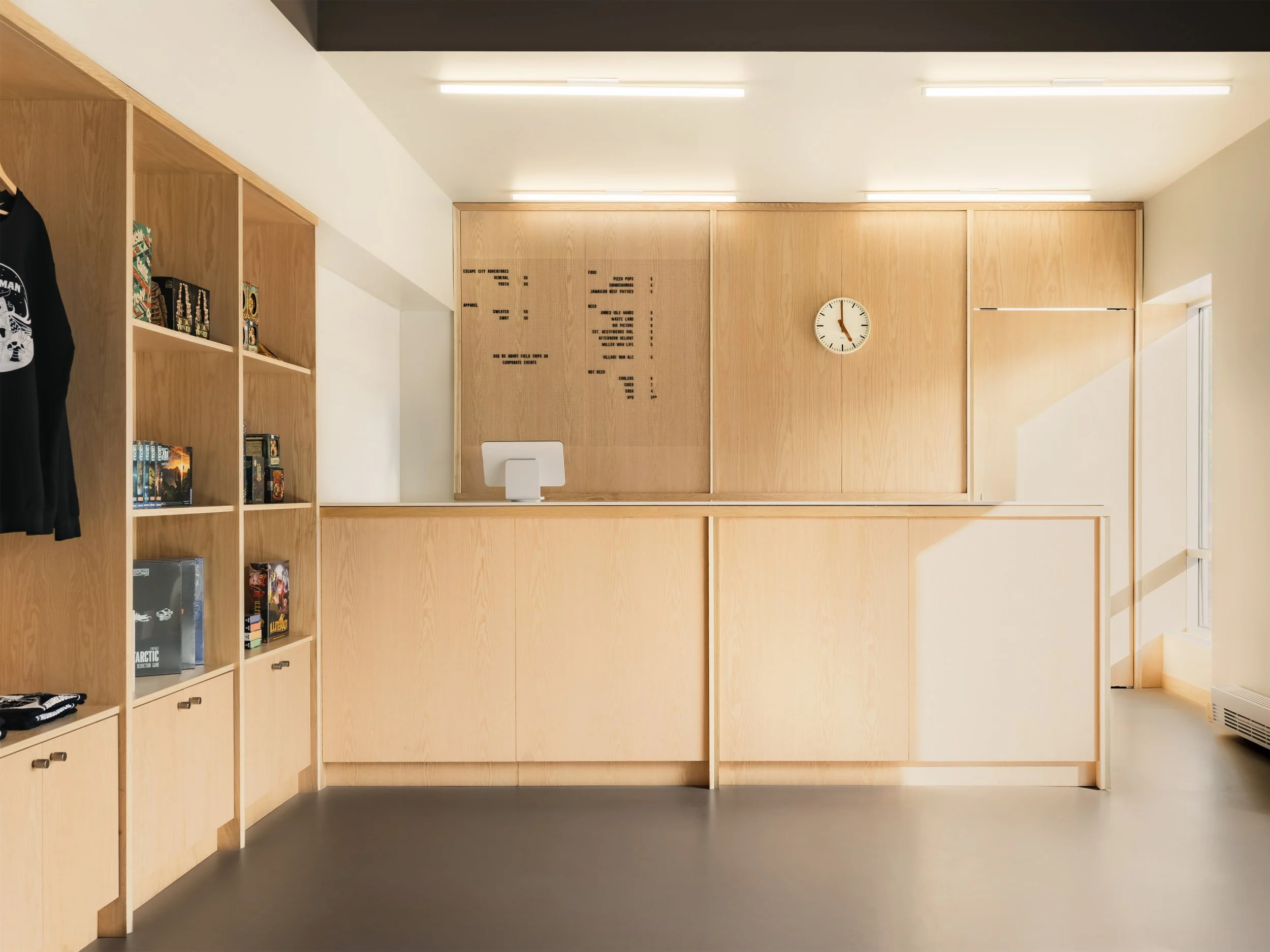 Front desk, made of custom millwork, of Escape City commercial interiors tenant improvement in Calgary, Alberta