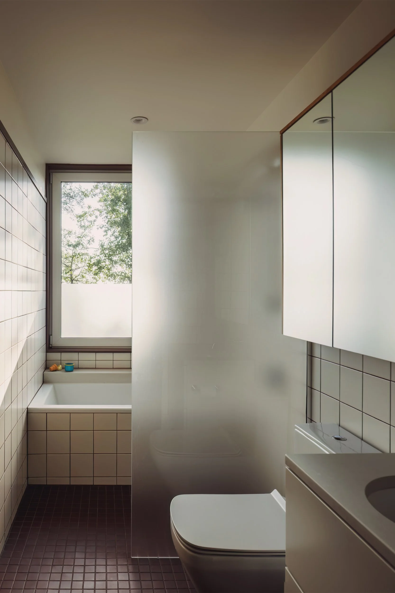 Main bathroom of architectural cabin at Wabamun, Alberta near Edmonton showing curbless shower, tiled wall, bathtub