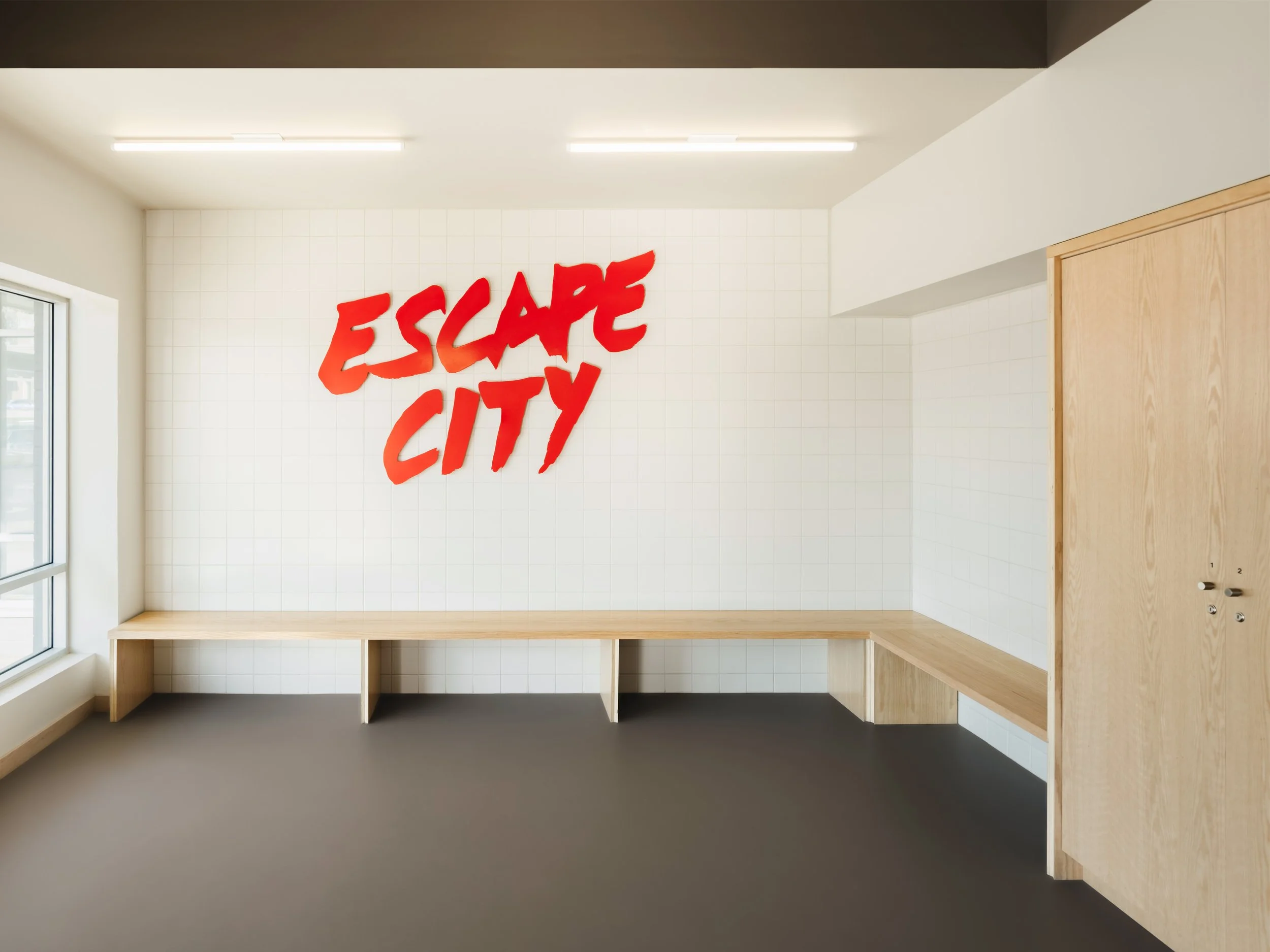 Custom made signage, bench, and millwork at Escape City commercial interiors tenant improvement in Calgary, Alberta