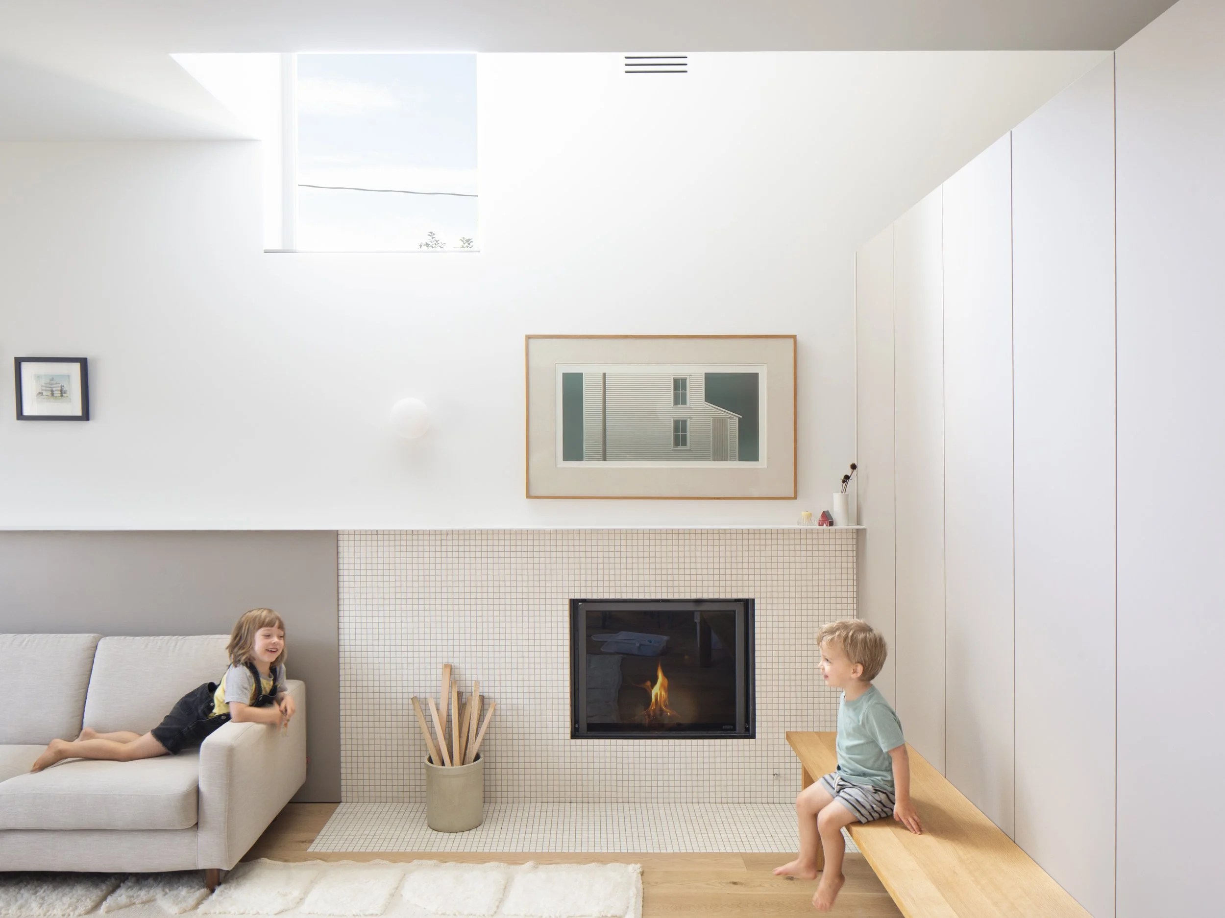 Living room of Bonnie Doon Duplex multi-family project in Bonnie Doon neighbourhood of Edmonton, Alberta, showing hardwood floor and energy efficient fireplace.
