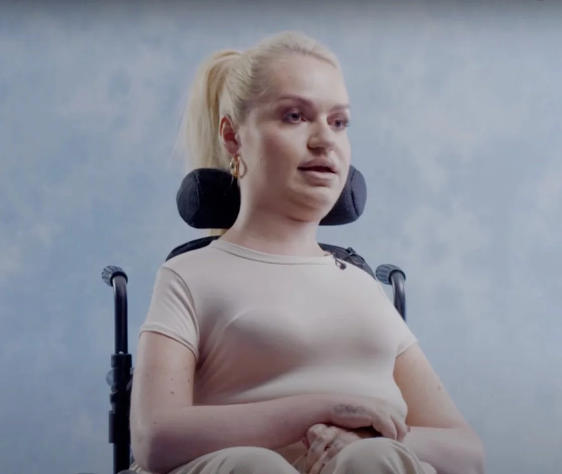 Tess in her wheel chair looking determined wearing her in a pony tail