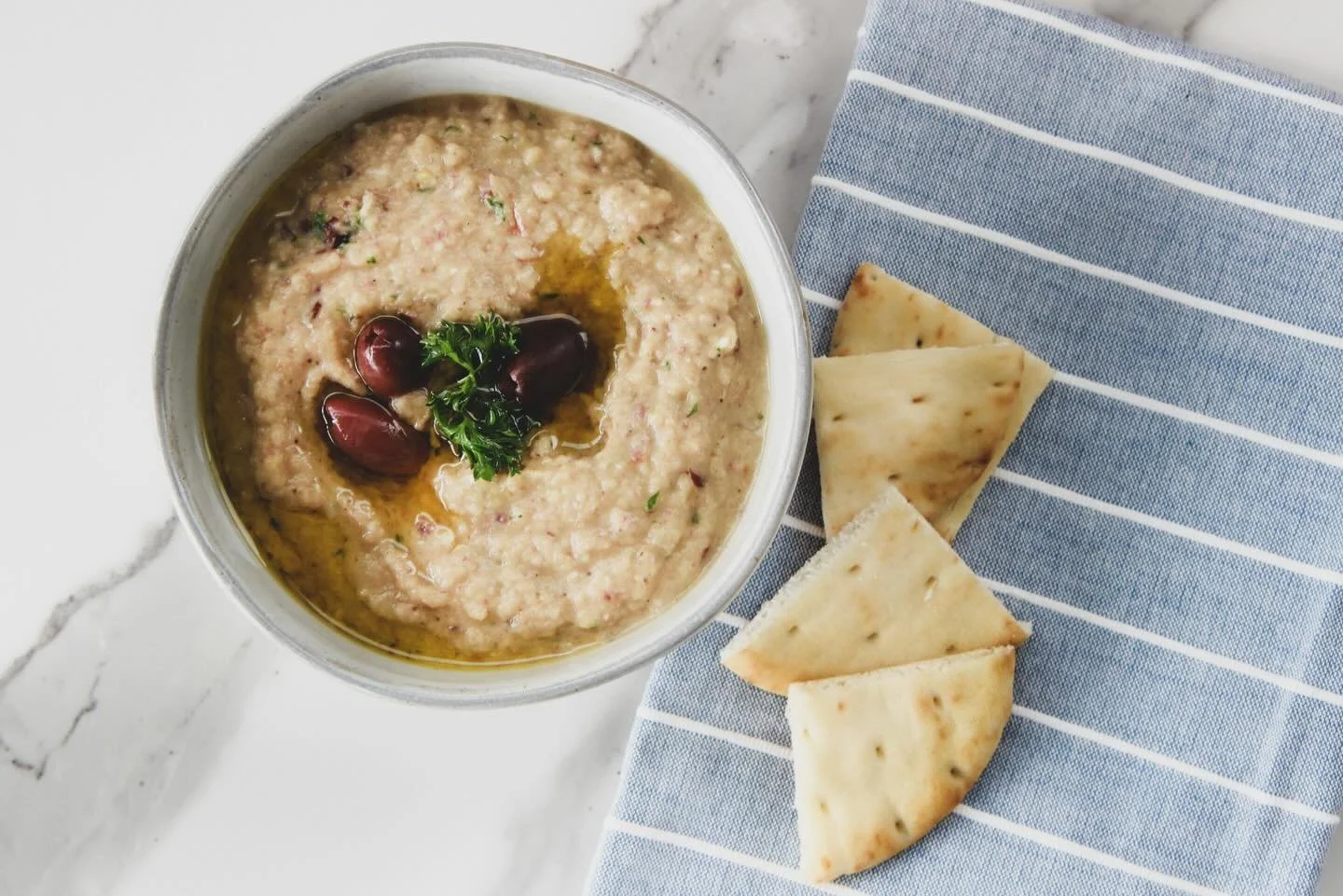 I once sat at a taverna up aways from the port in Aegina, a hefty black cat lounging at my feet as my only company, snacking on melizanosalata. Despite the many years that have passed, I still recall the taste of the eggplant on my tongue, the smell 