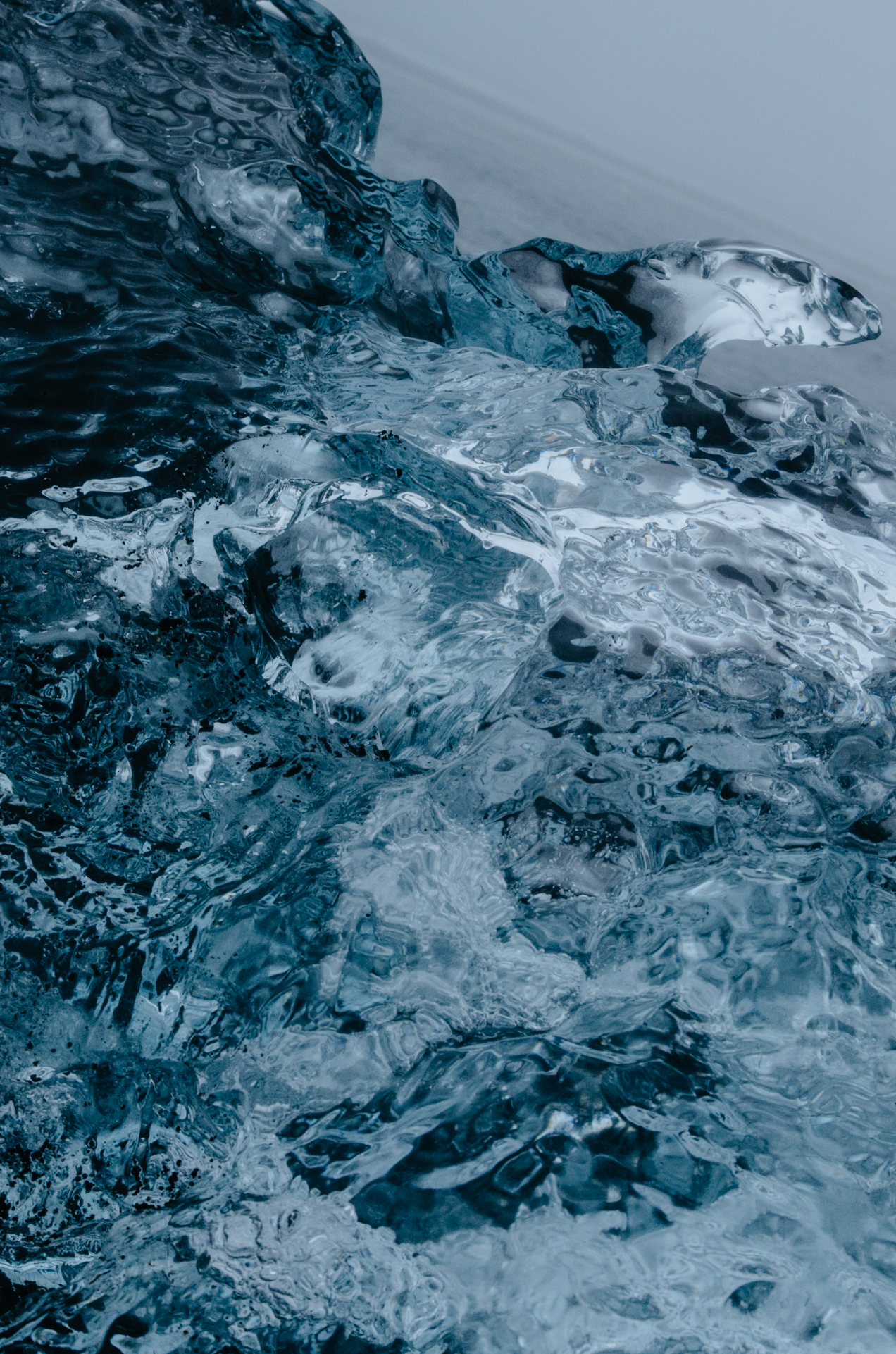 Photographie de nature et abstraite par Mélissa Pottier. Gros plan sur une vague de glace aux tonalités bleues intenses, pour une composition sensorielle et graphique.