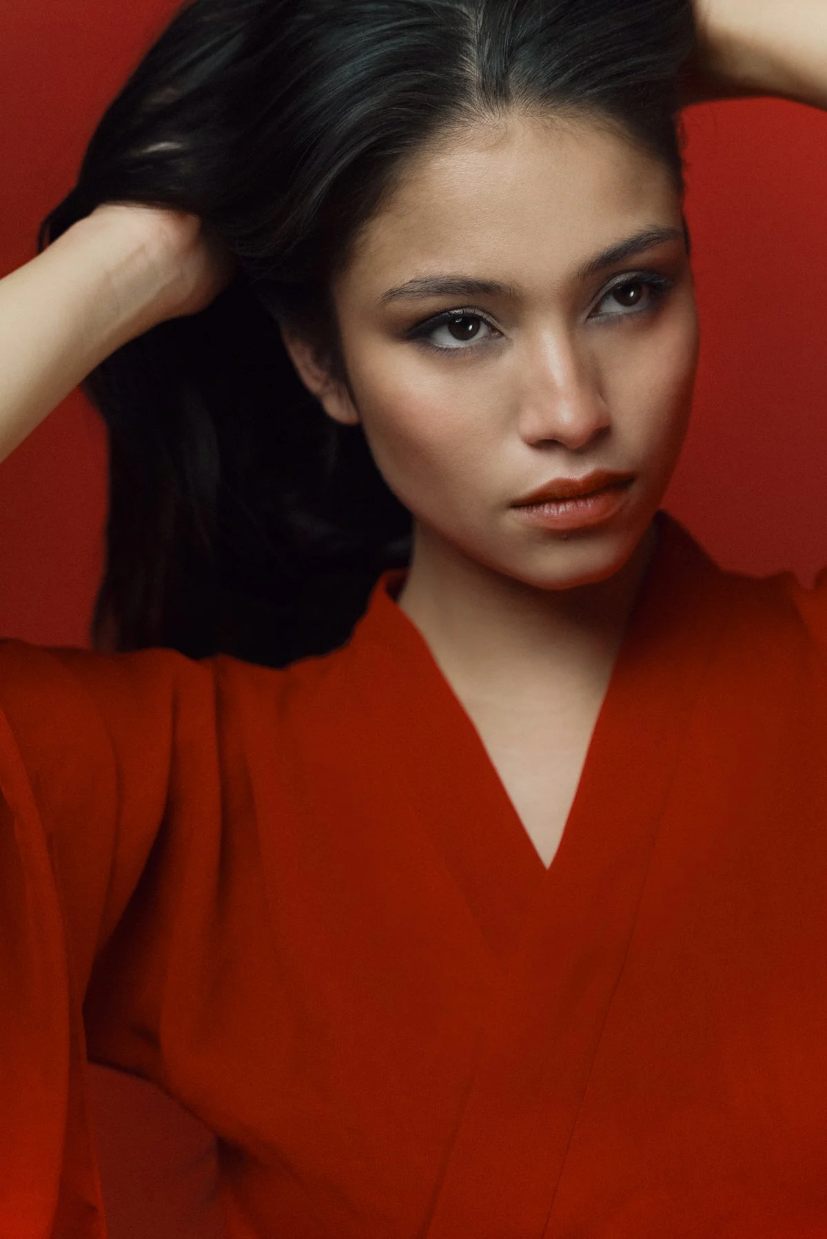 Éditorial mode par Mélissa Pottier. Portrait intense d'une femme en robe rouge, regard expressif et cadrage serré pour un rendu à fort impact visuel.