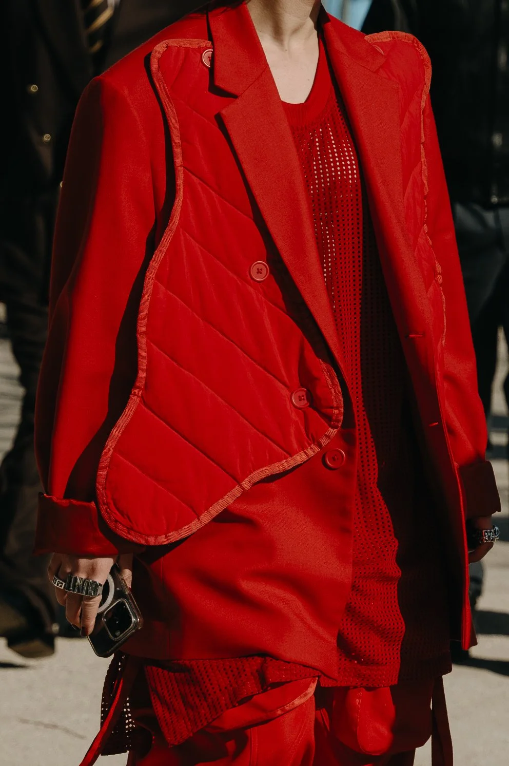 Éditorial mode par Mélissa Pottier. Costume rouge vif à double boutonnage, photographié dans un contexte urbain pour un look affirmé et impactant.