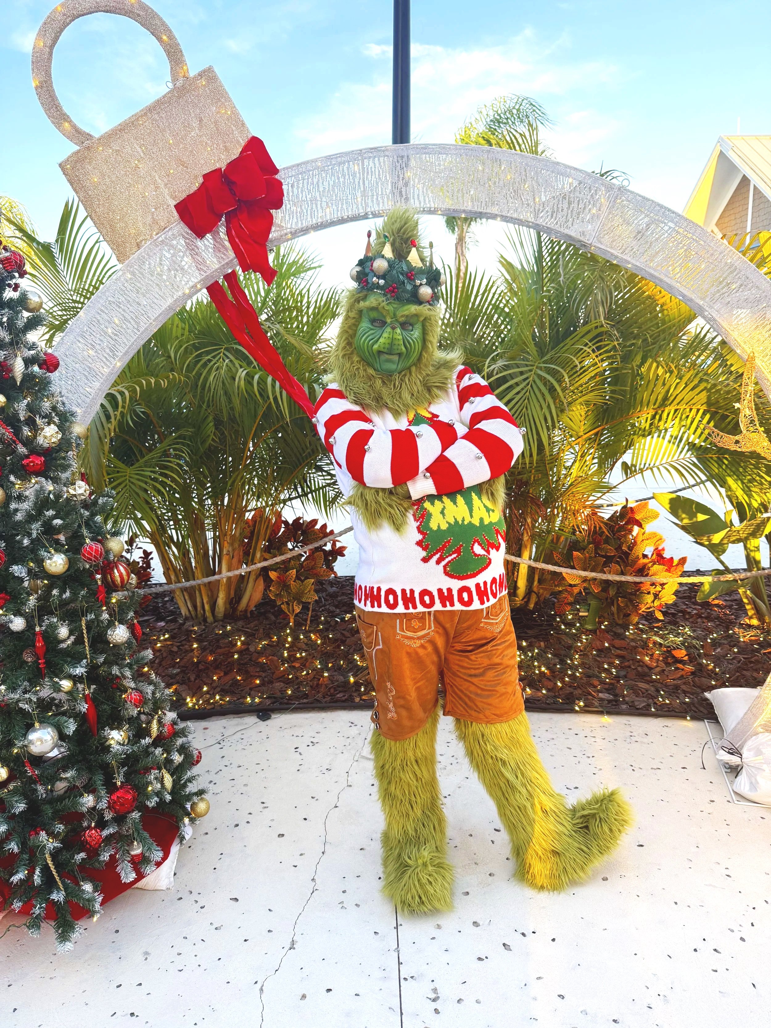 Grinch-inspired holiday character performer at a Christmas party with children.