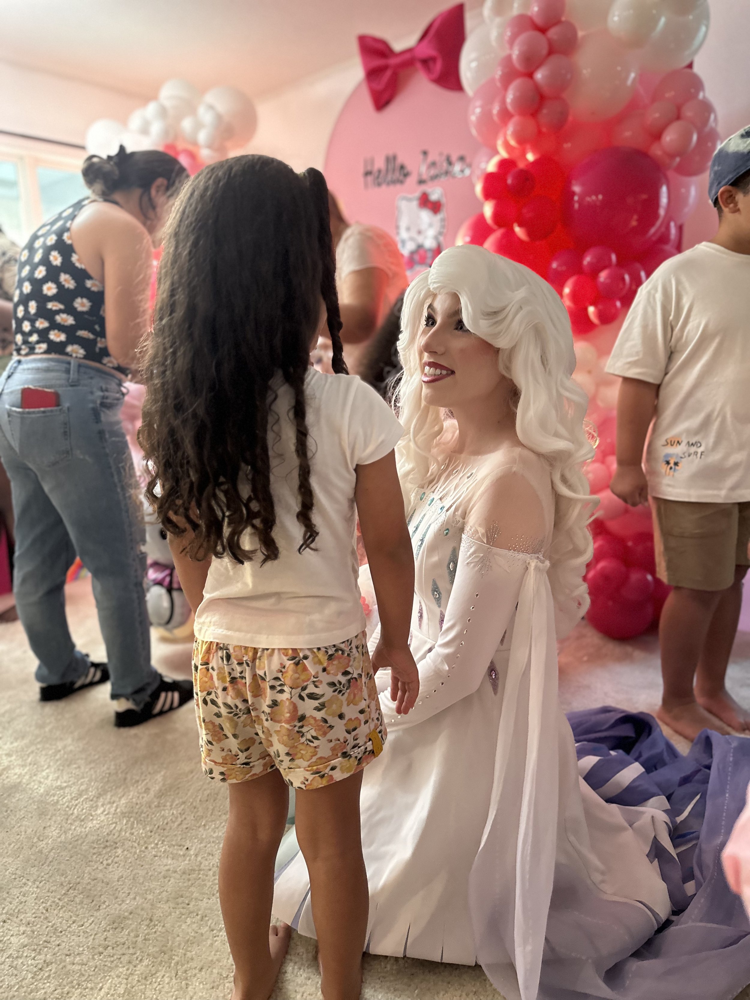 a woman kneeling down to a little girl dressed as Elsa from Disney's frozen for a princess party in Orlando