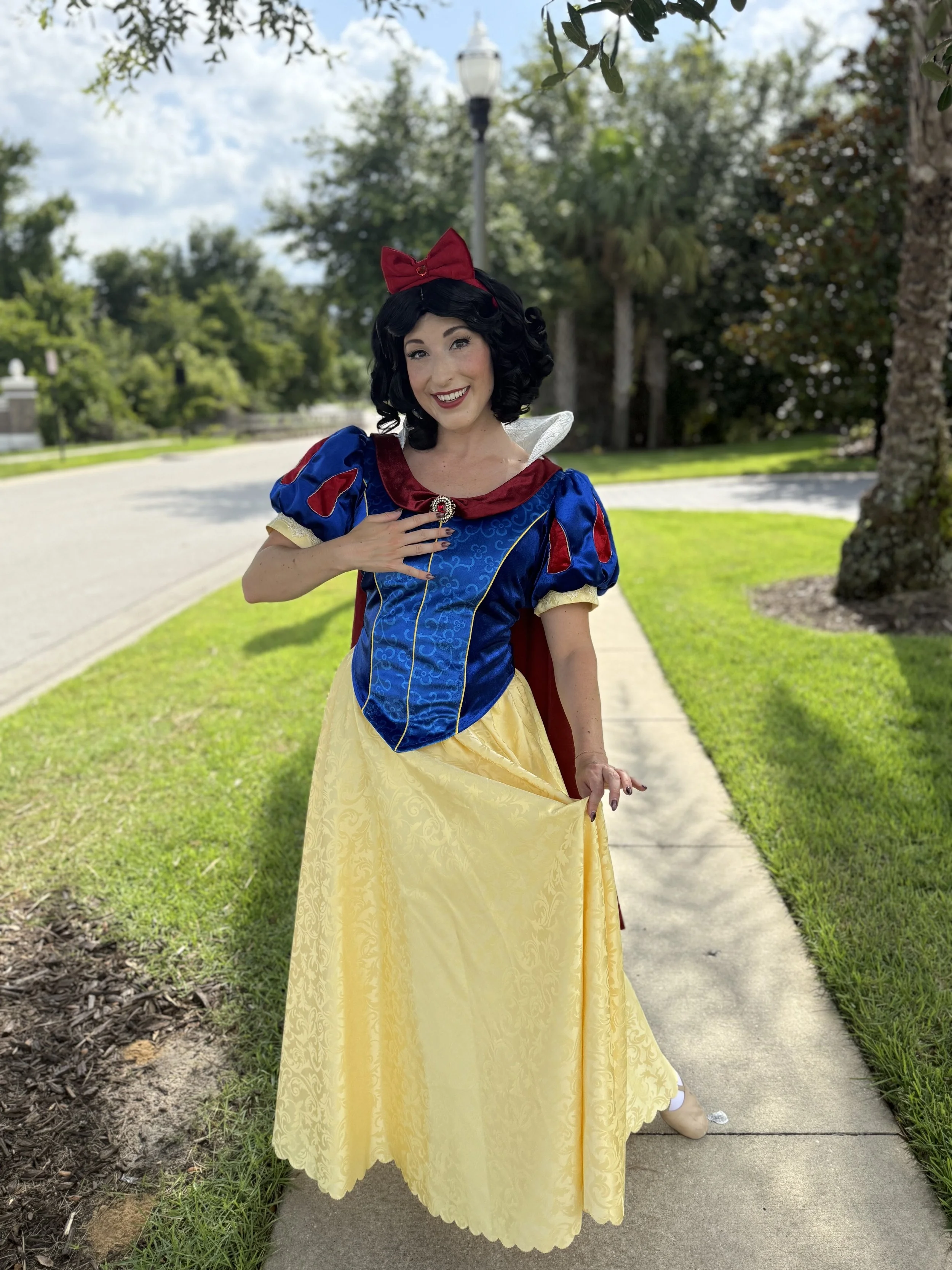 now White princess performer at a children's birthday party with a beautiful blue and yellow gown, perfect for princess parties, meet-and-greets, and magical celebrations.