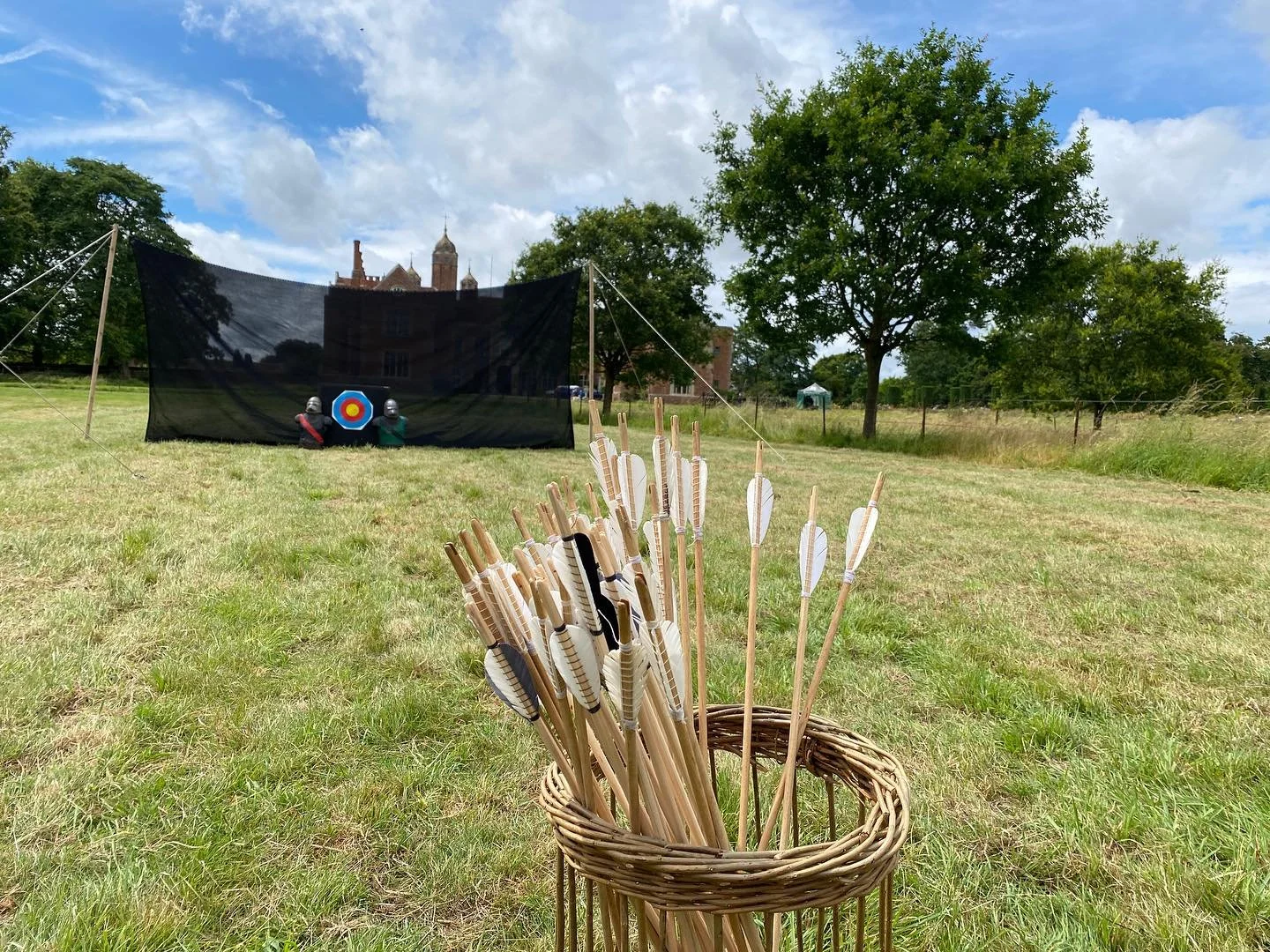Basket of white fletched arrows on a lawn