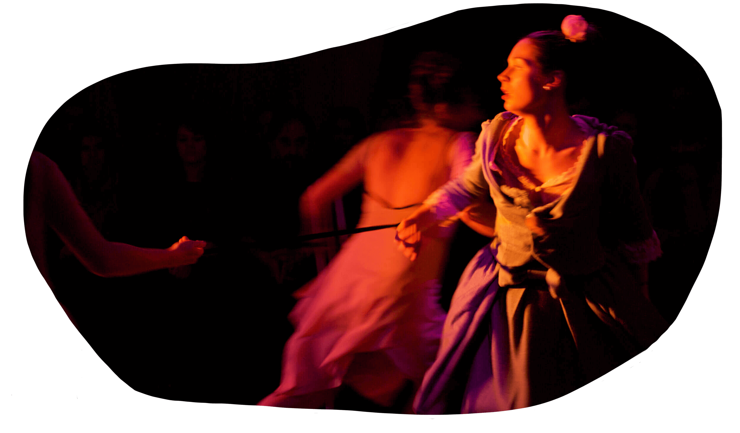 A stage scene from 'A Doll's House' with performers, one woman wearing a pretty dress being pulled by the others with ribbons under dramatic lighting.