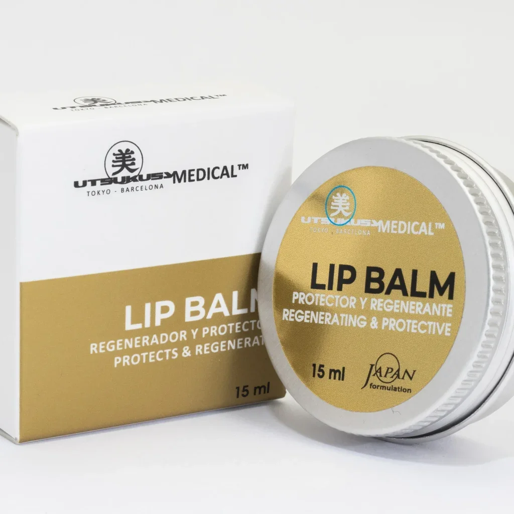 Envase y caja de bálsamo labial con etiqueta dorada, marca 'Utsukusa Medical', que indica que es regenerador y protector, de 15 ml, formulado en Japón.