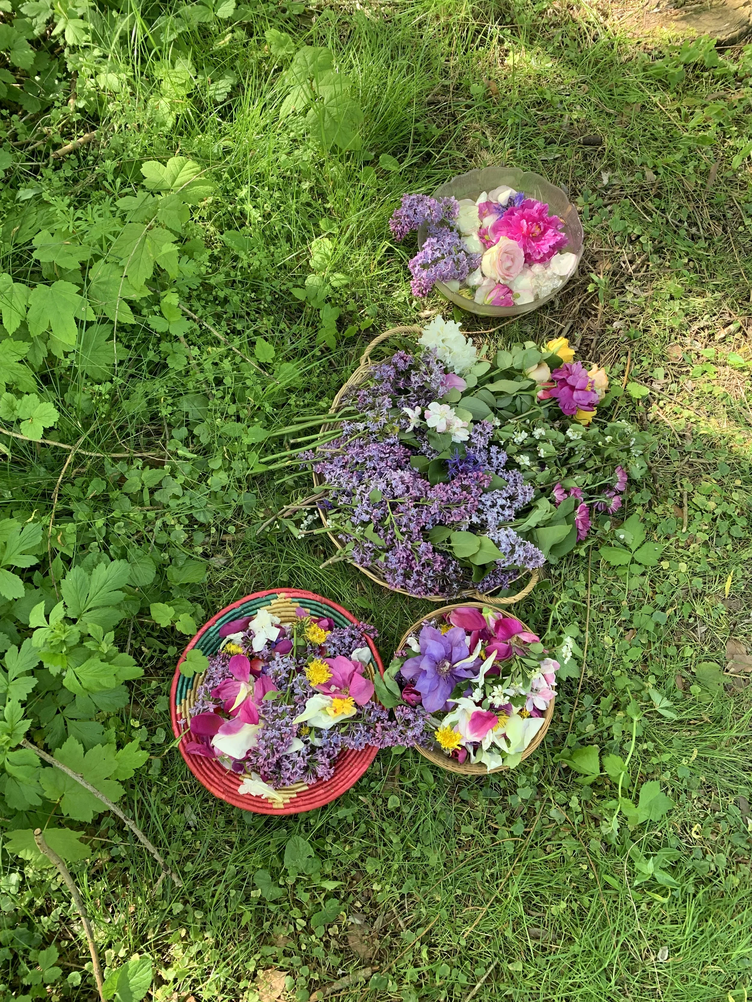 Four baskets filled with colorful flowers from a mother blessing ritual.
