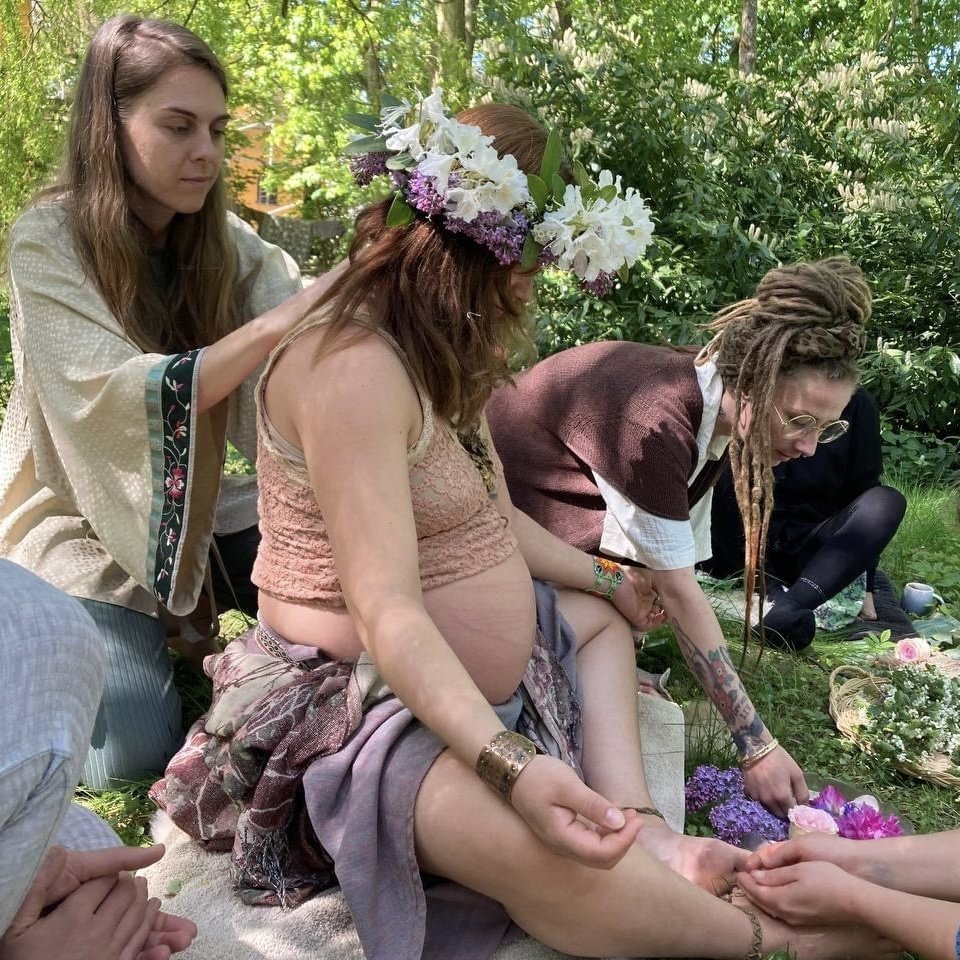 Livia's mother blessing. She is wearing a flower crown and is being blessed by everyone. Facilitated by Kaya.