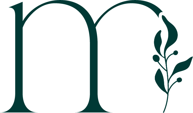 A large stylized letter 'm' with a decorative leafy branch on the right side.