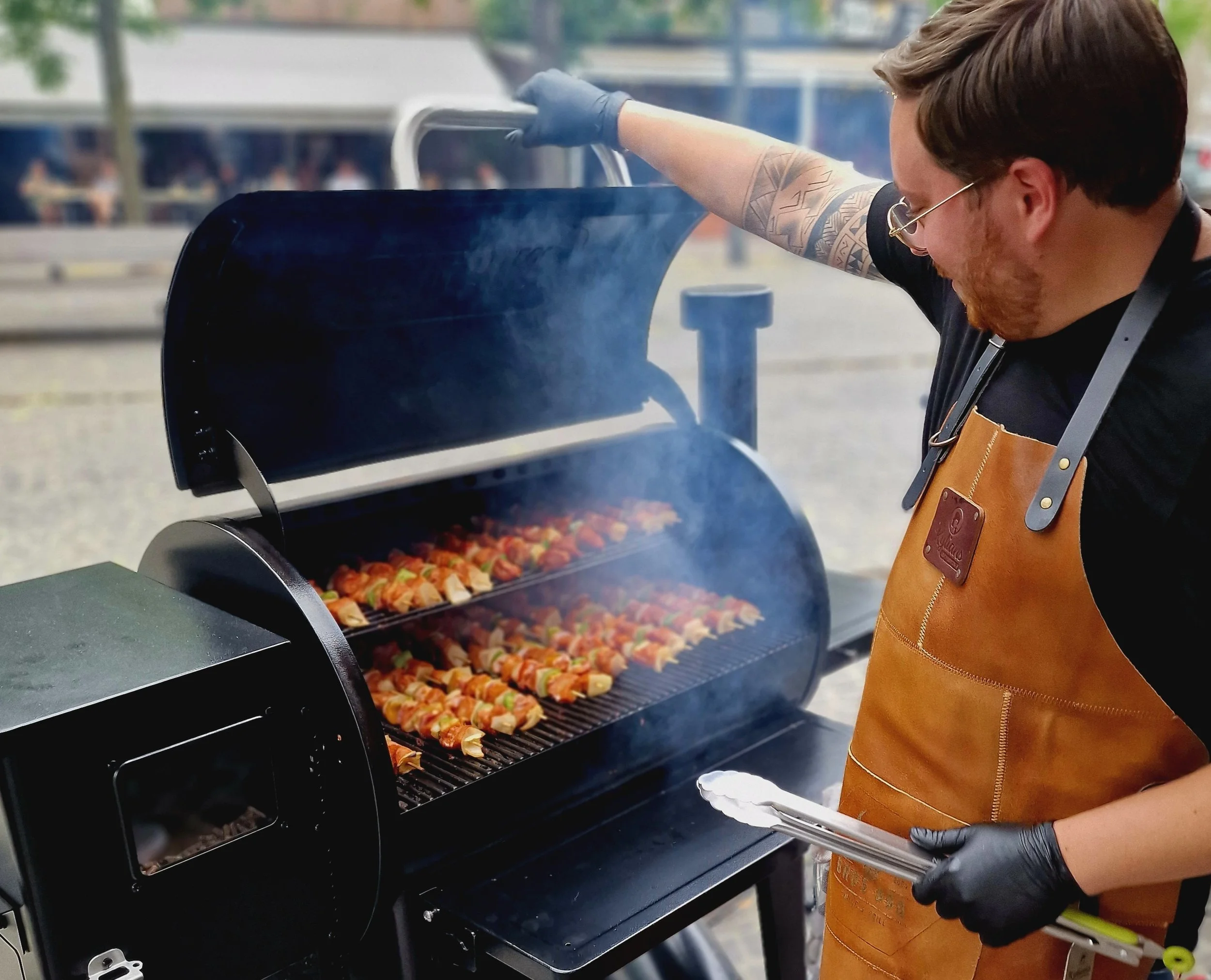 Man die barbecue-vlees spiezen bereidt op een grill buiten.