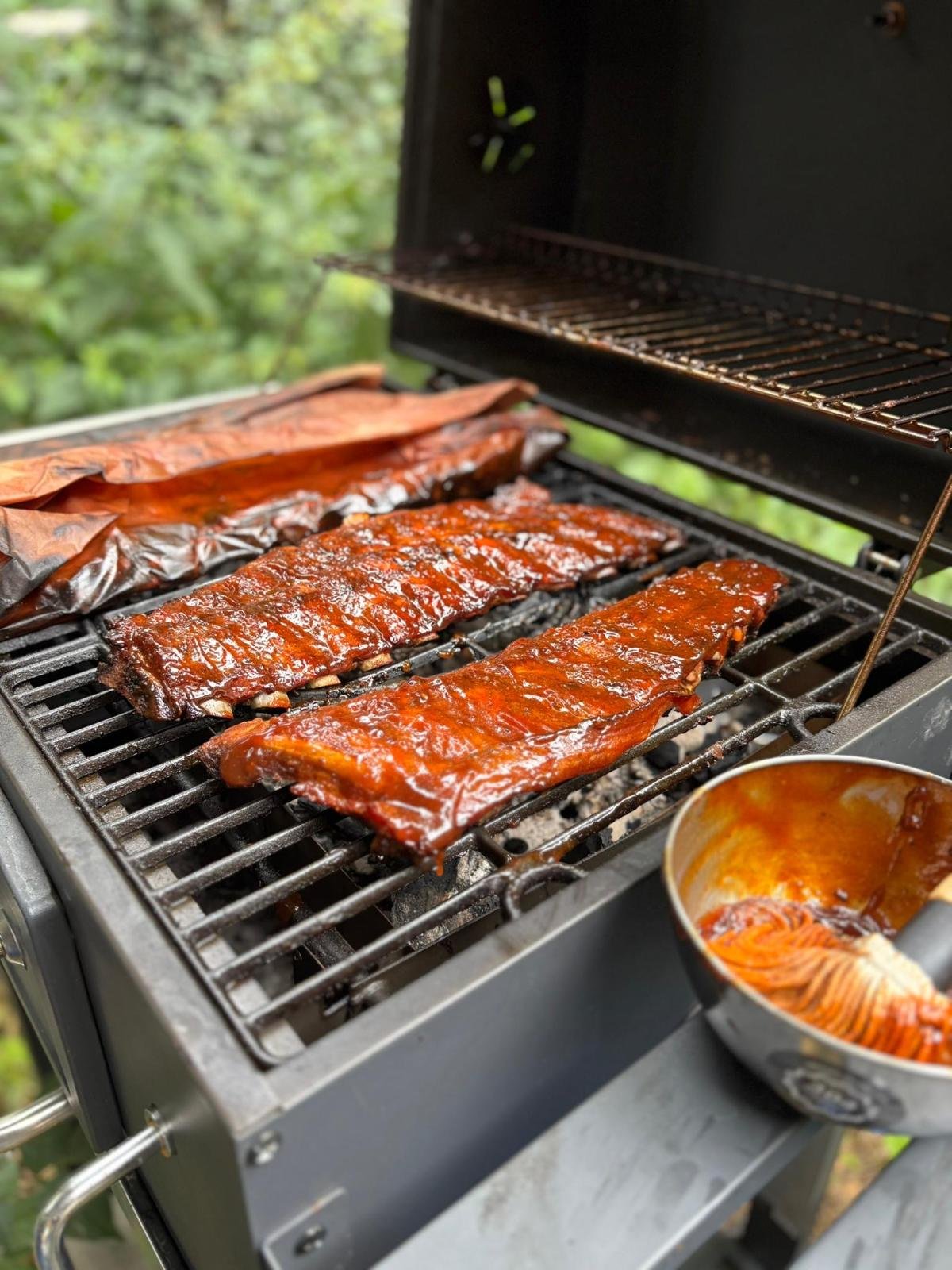 Barbecue met gerookte vleesschijven en saus in een kom.