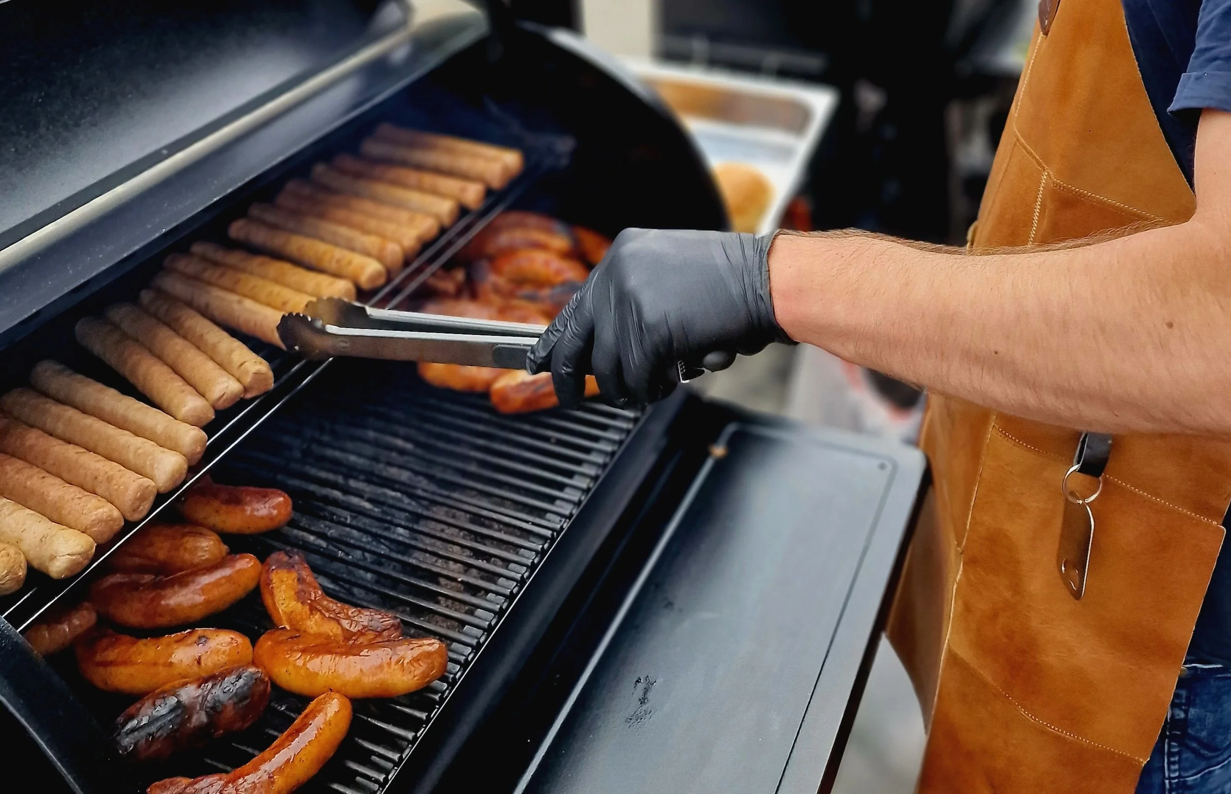 Persoon die barbecue sausages en vleesgrillt en rondom saus en voorbereidingen