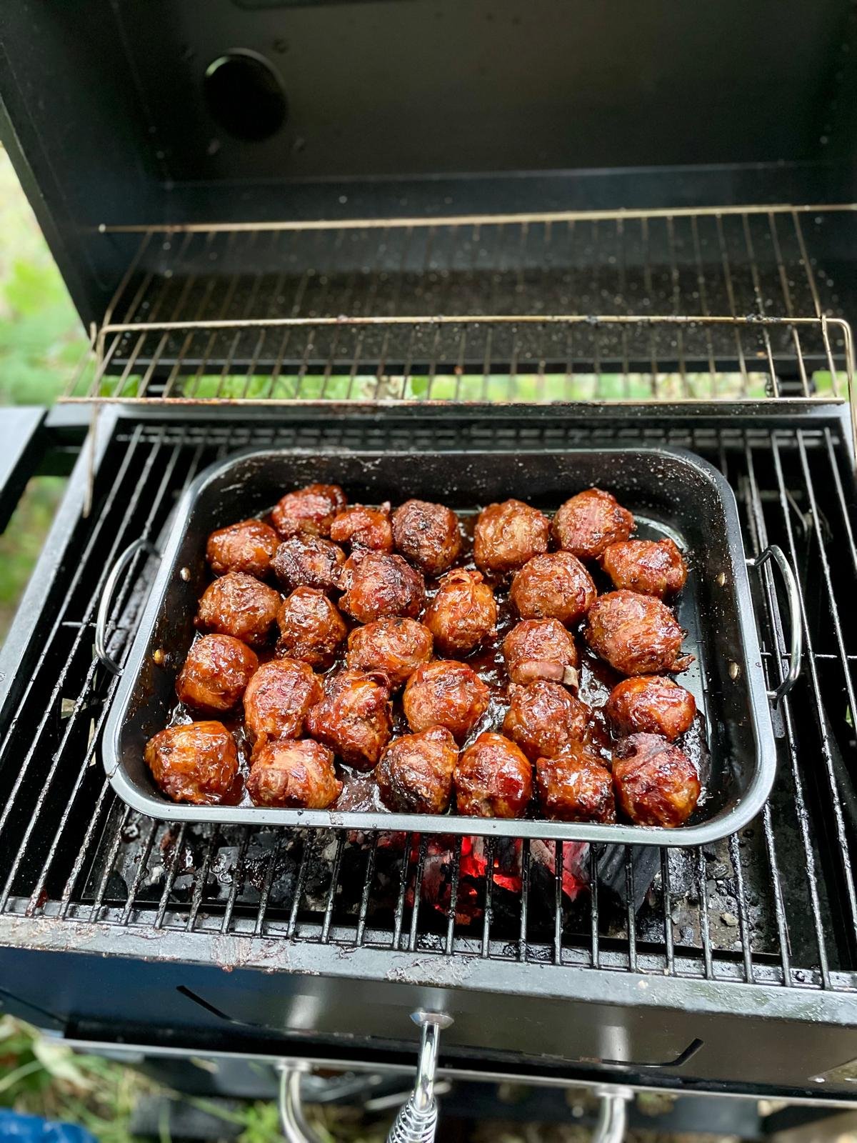 Geroosterde gehaktballetjes op een barbecue.