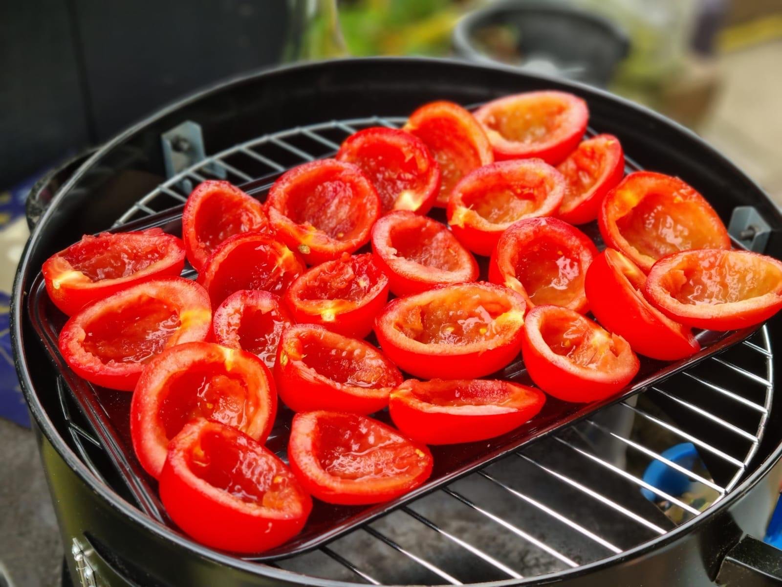 Geroosterde halve tomaten op een grillplate op een barbecue