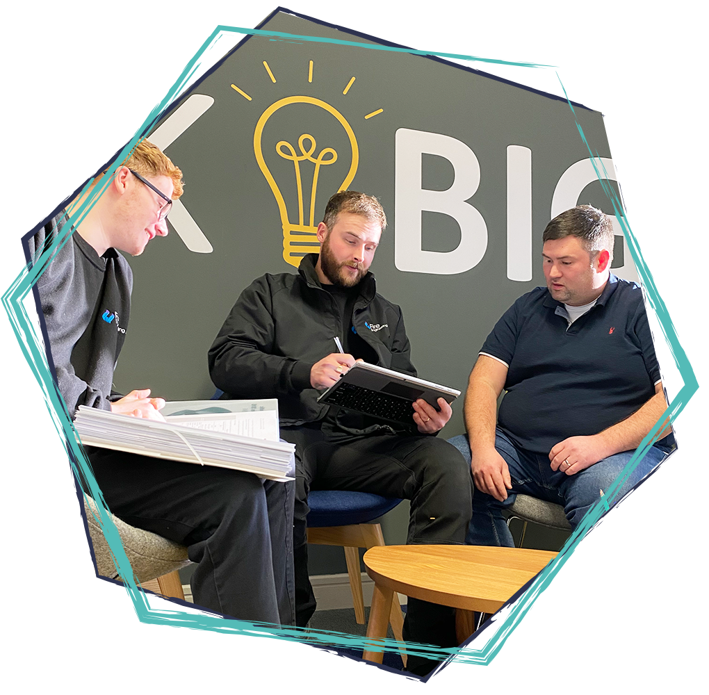 Three men sitting and discussing in front of a wall with a large lightbulb graphic and the word "BIG".