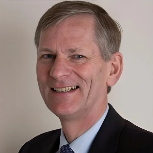 Portrait of a middle-aged man in a suit smiling.
