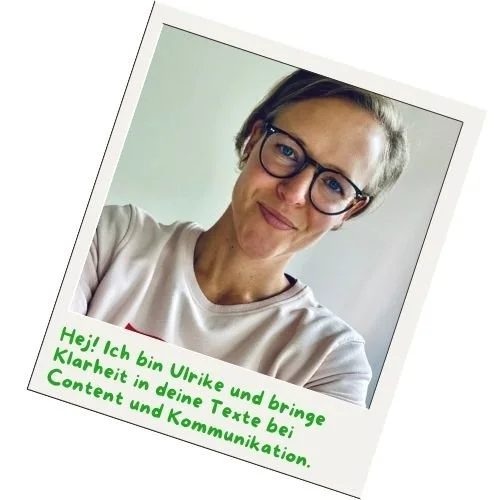 Frau mit kurzen Haaren, sie traegt eine Brille, beigen Pullover und sie  laechelt