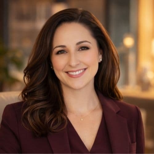 Eine Frau mit langen dunklen Haaren und einer schwarzen Jacke mit V-Ausschnitt