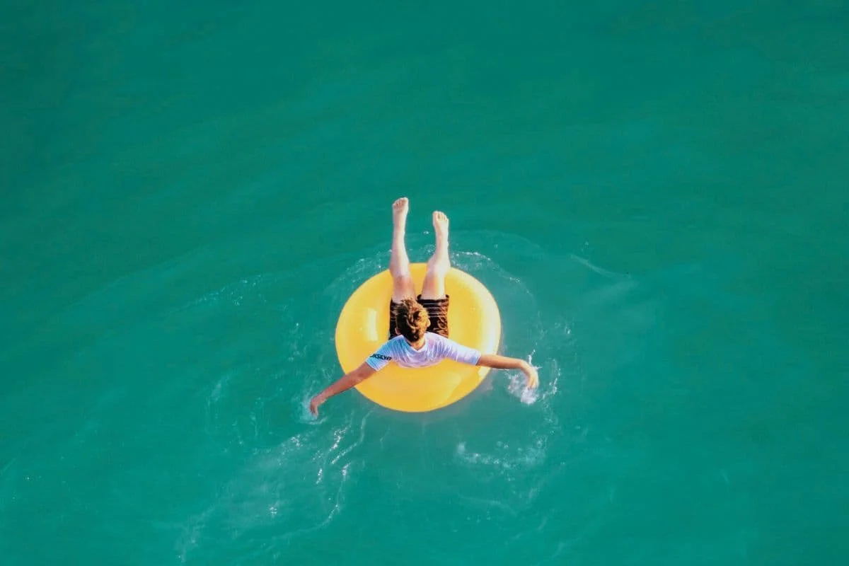 Ein gelber Schwimmring mit einem Jungen im Pool