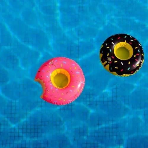 Zwei aufblasbare Schwimmreifen in Form von Donuts mit bunten Streuseln im Wasser.
