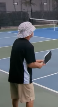 Pickleball player wearing a cotton terry cloth bucket hat to stay cool.