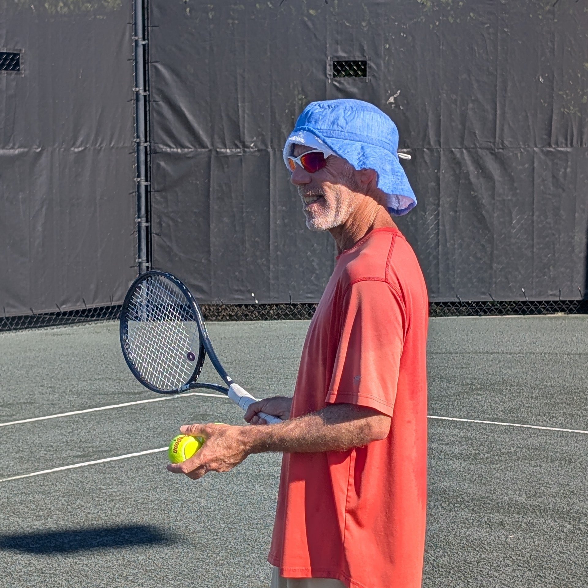 A tennis player wearing a cooler bucket hat to stay cool on a hot day.