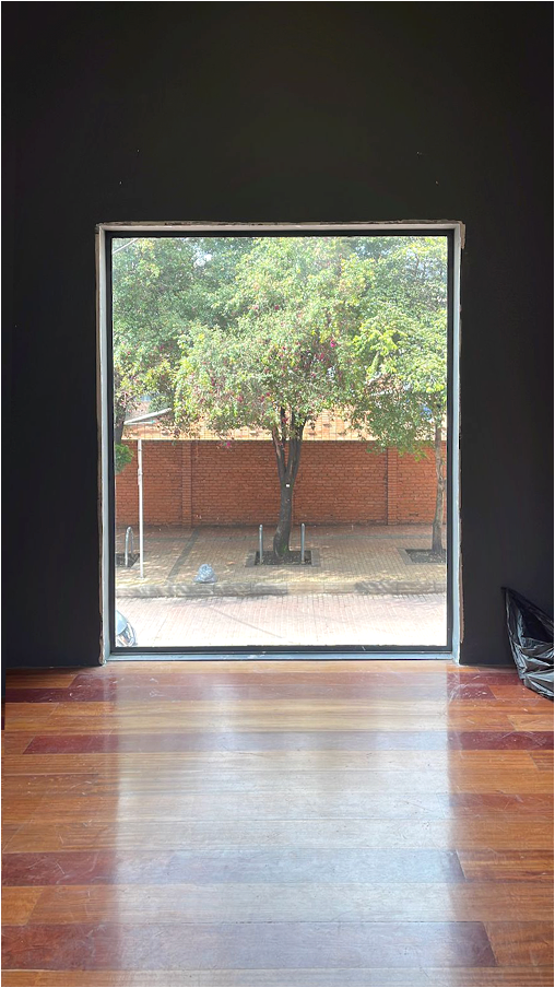 Serie “Encuentros-
Señal morse siendo instalada en un árbol que se ve desde la ventana de sala de exposición
2023