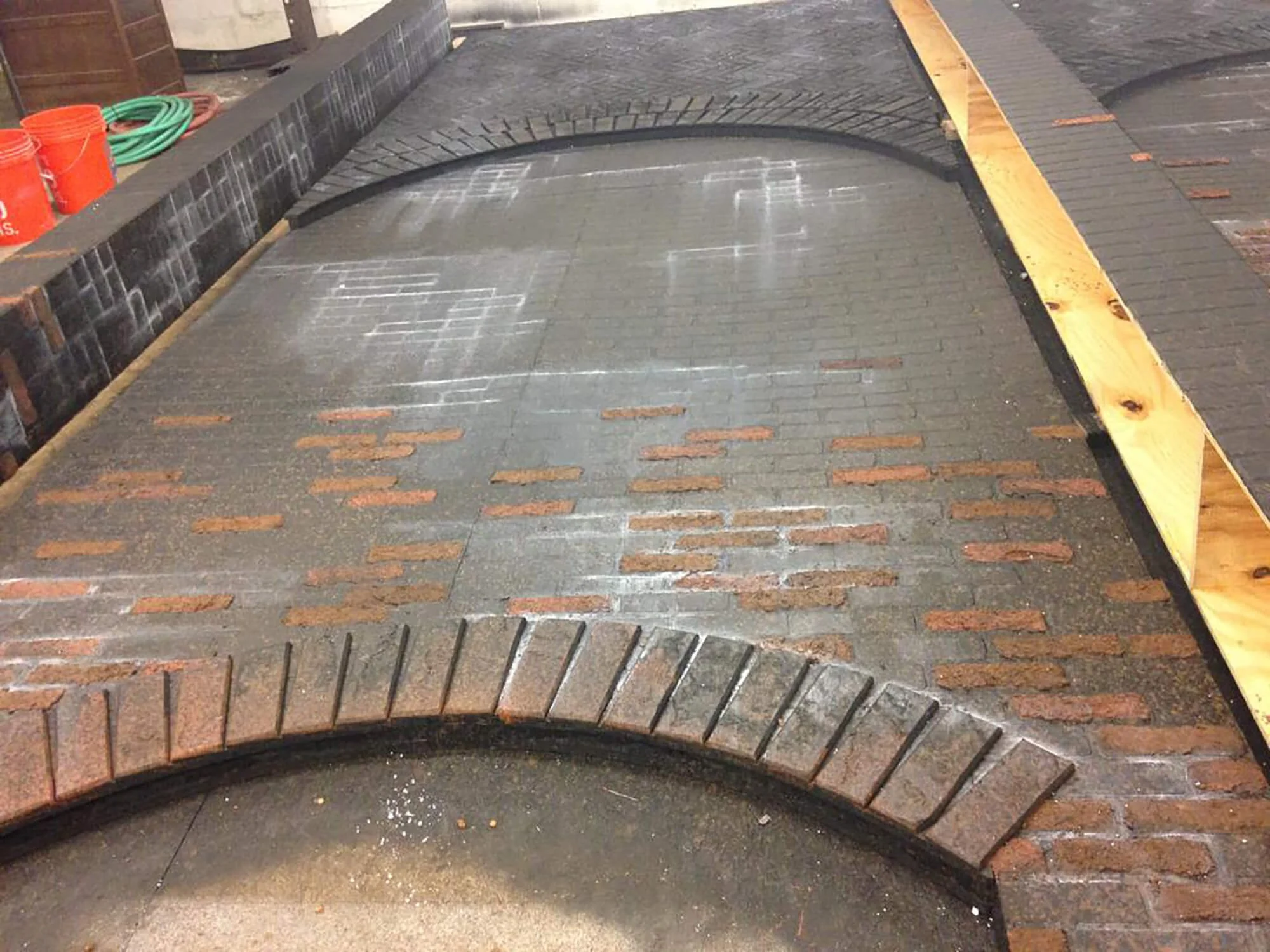 Under construction brick pathway with wooden borders and chalk markings.