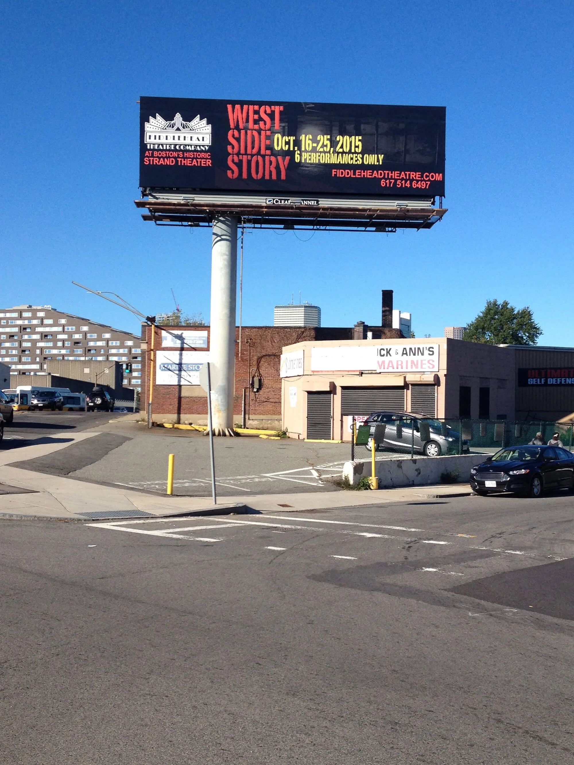 A billboard advertising a theatrical production titled "West Side Story" by the Boston's Historic Strand Theater, displaying dates October 16-25, 2015, and mentioning 6 performances only. The billboard is mounted on a pole in an urban area with a par