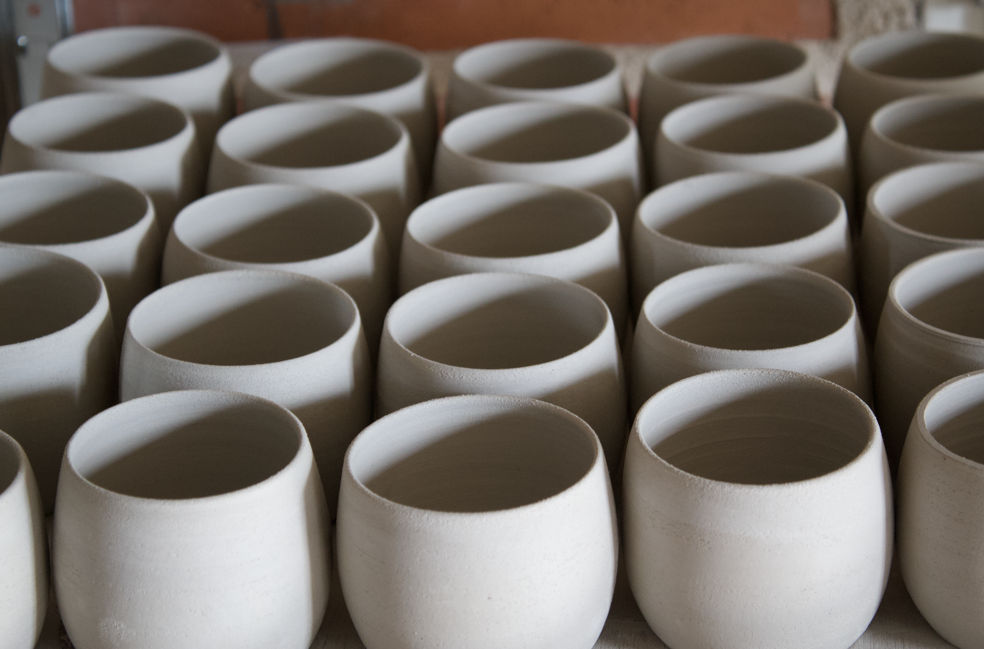 Groupe de pots en céramique blancs vides alignés sur une surface