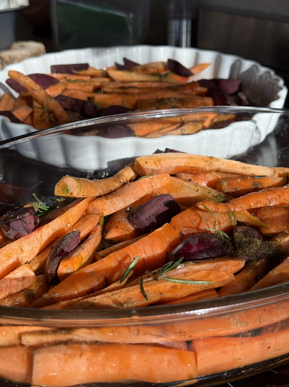 Légumes rôtis comprenant des carottes coupées en morceaux avec des herbes, dans un plat en verre.