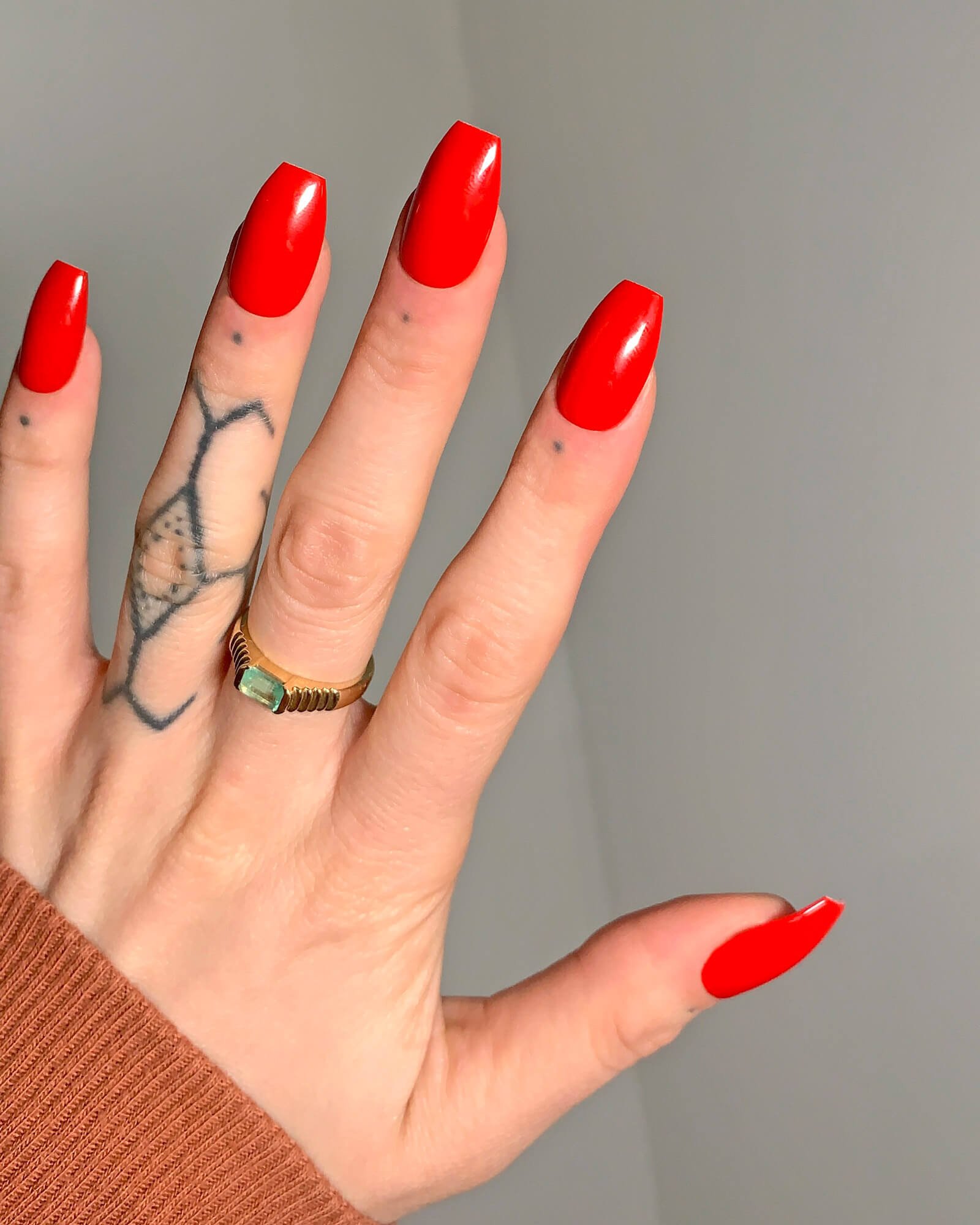 Bright red press-on nails in short coffin chic shape.