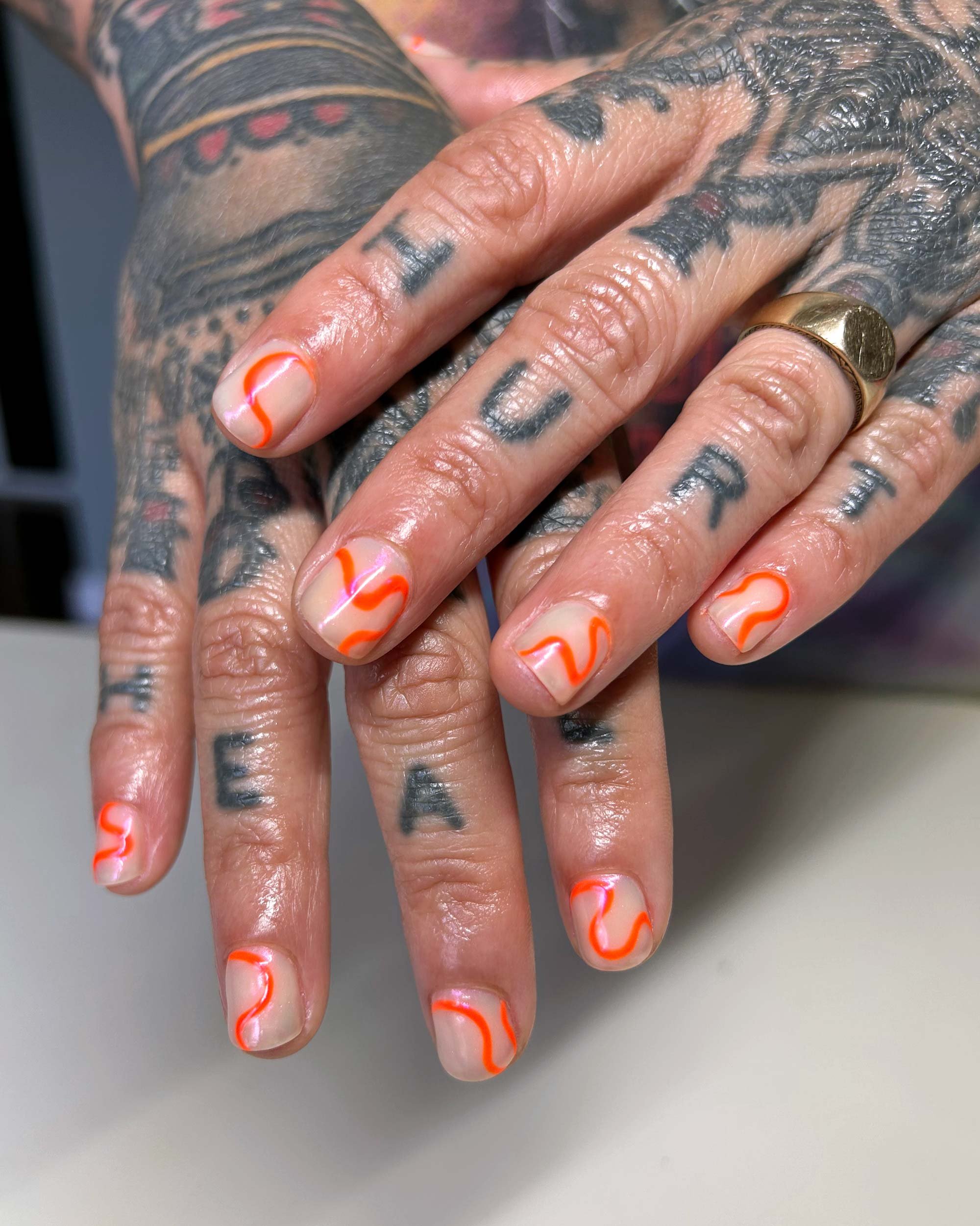 Hand-painted-nail-art-on-short-nails-with-orange-squiggles.jpeg
