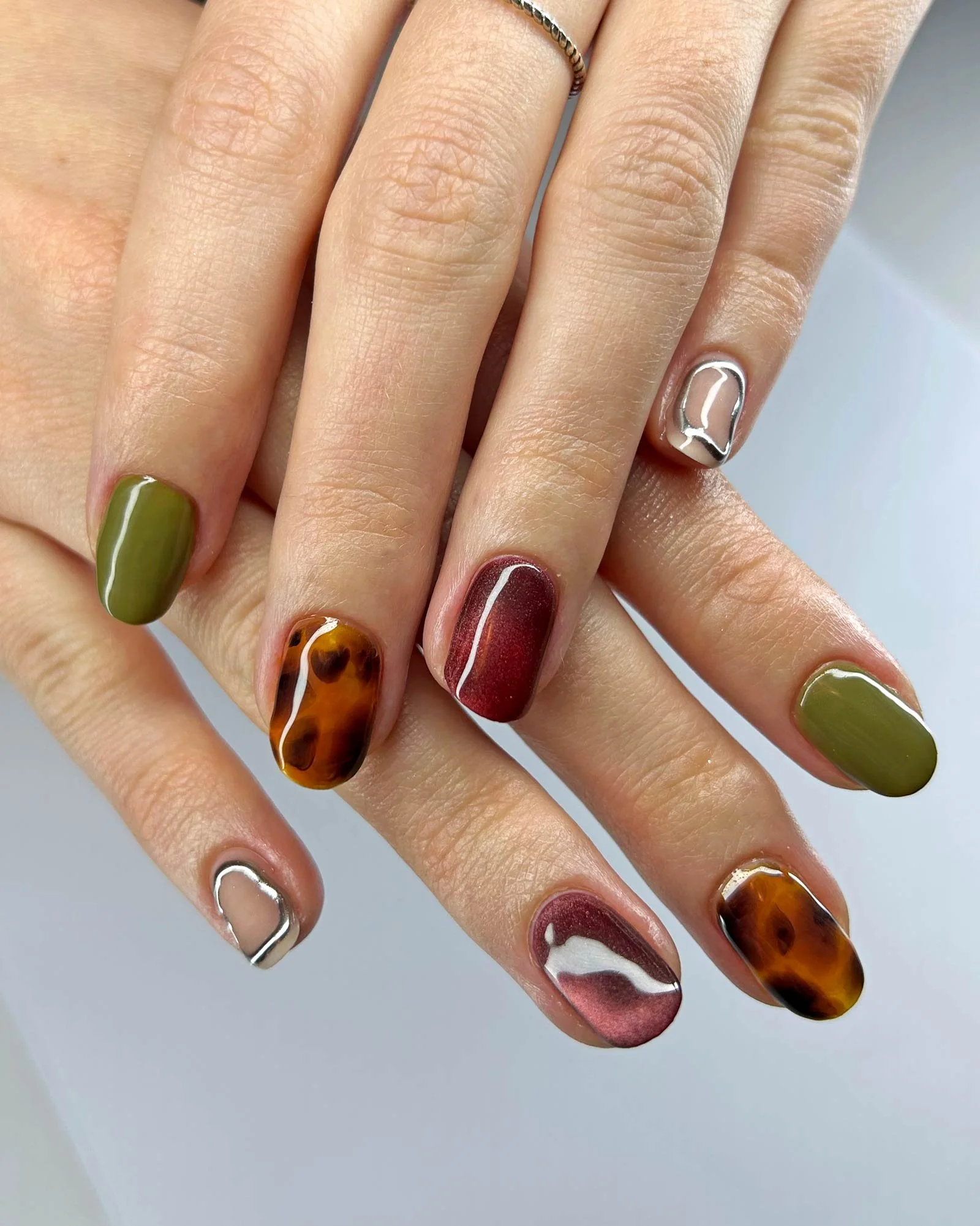 Tortoise-shell,-Chrome-nail-art,-cat-eye-polish,-and-olive-green-gel-on-natural-nails.jpg
