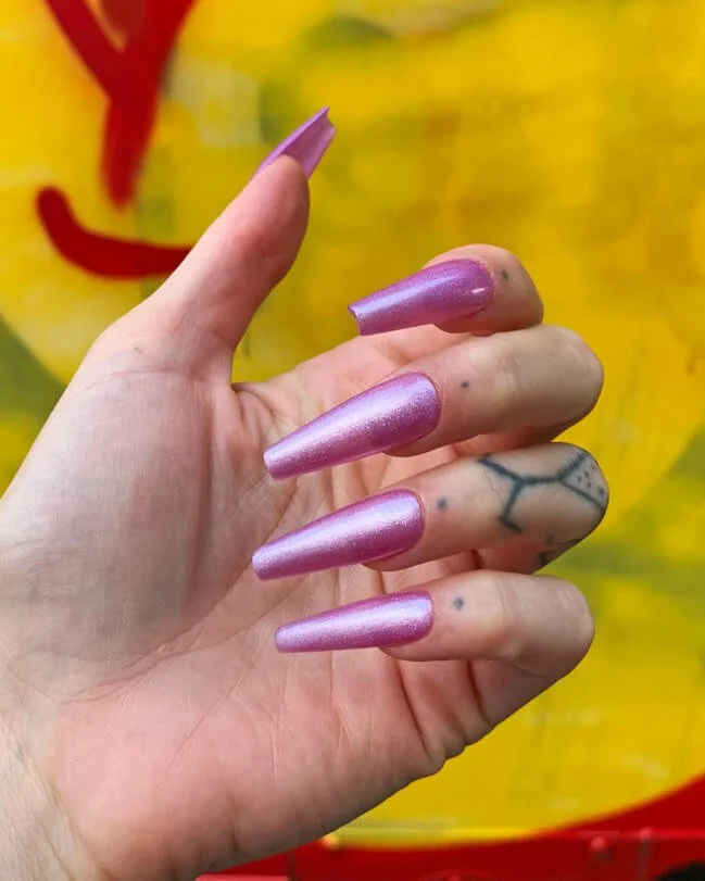 Model wearing the Frosty Pink nail set in long coffin.